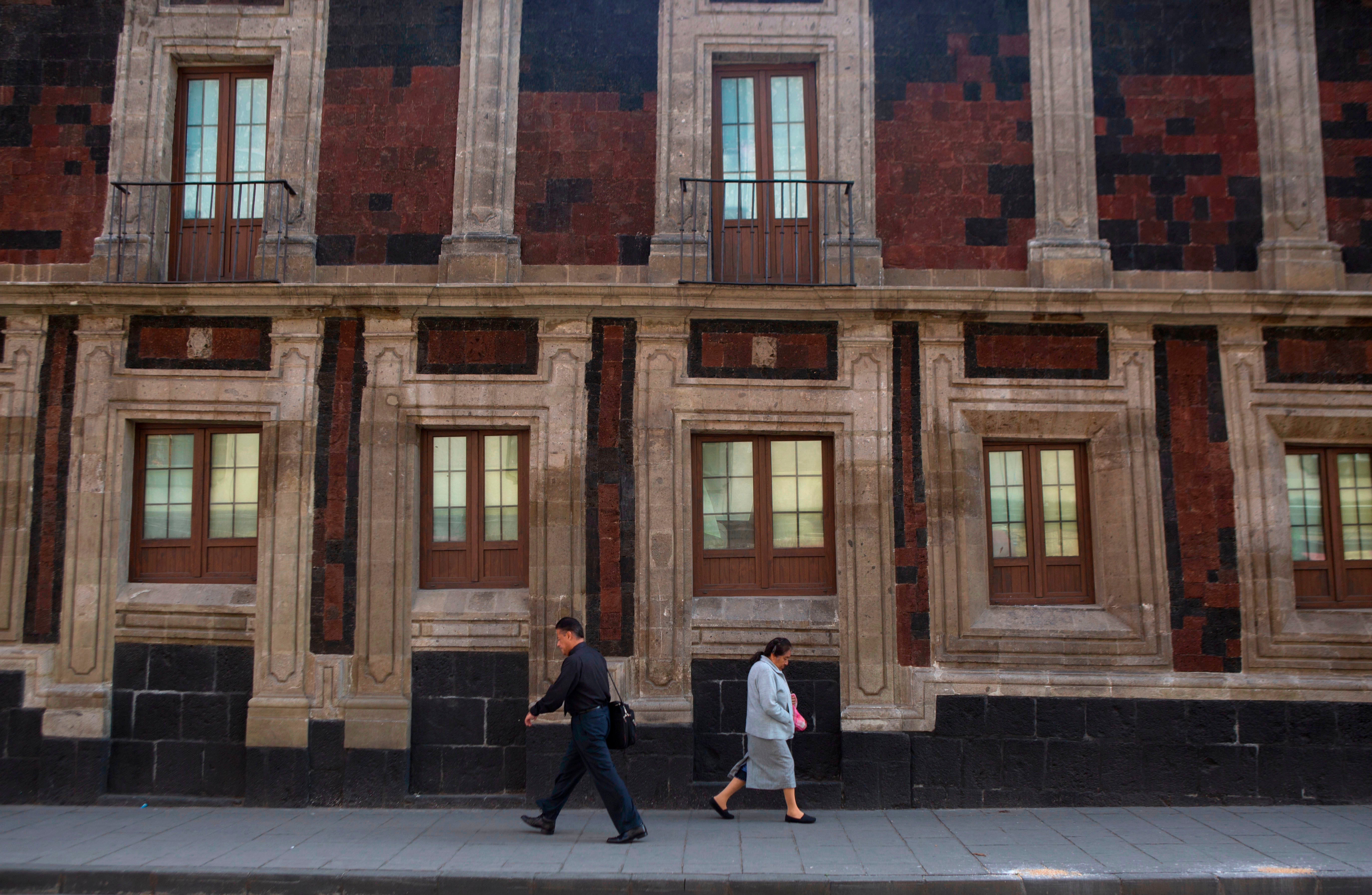 Pedestrians walk past a slightly tilted historic building in downtown Mexico City, June 15, 2016