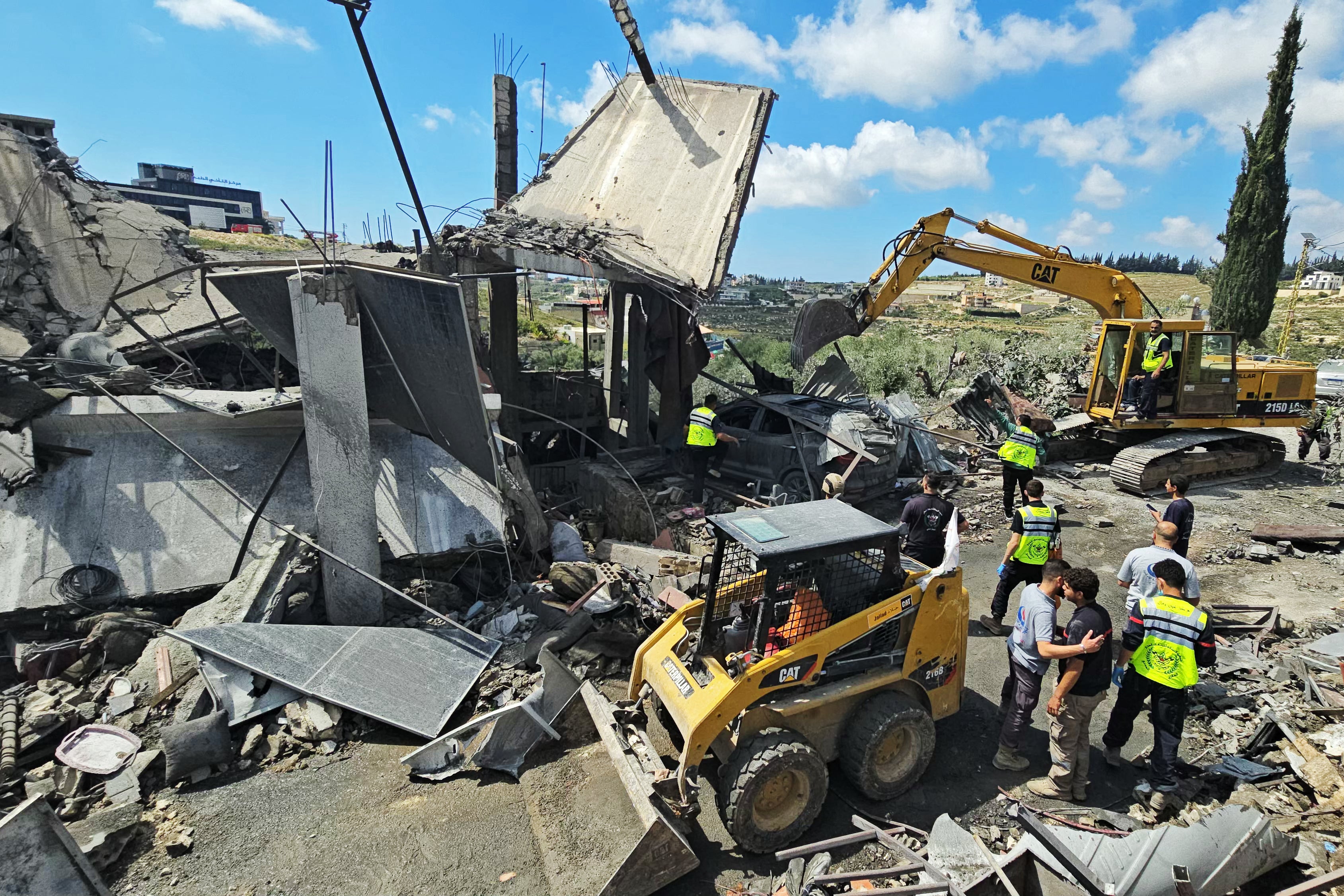 First responders search for survivors amongst the rubble at the site of an Israeli airstrike that targeted the southern Lebanese village of Ain Baal on May 1