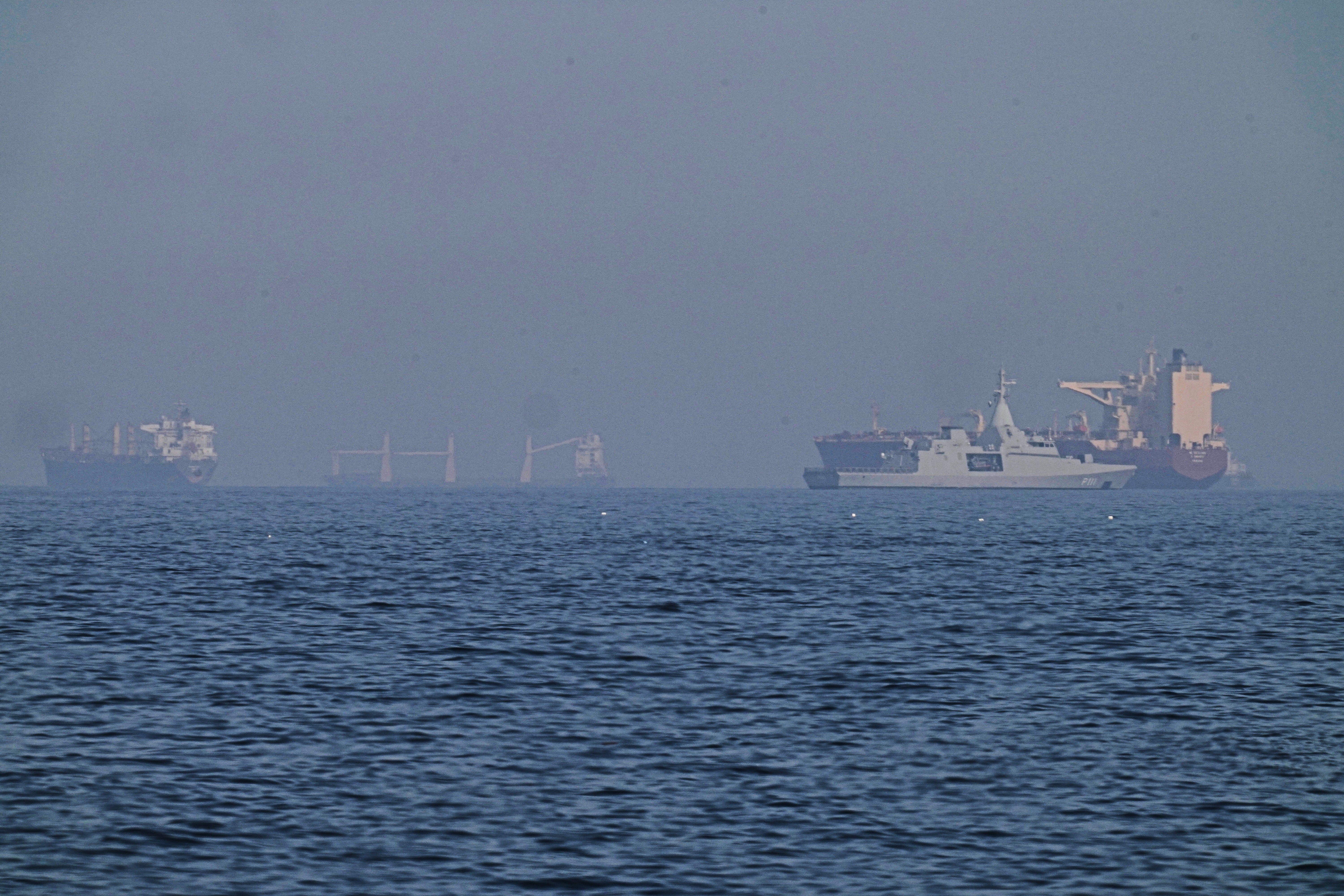 An Emirati patrol boat, second from right, is near a tanker anchored in the Gulf of Oman near the Strait of Hormuz