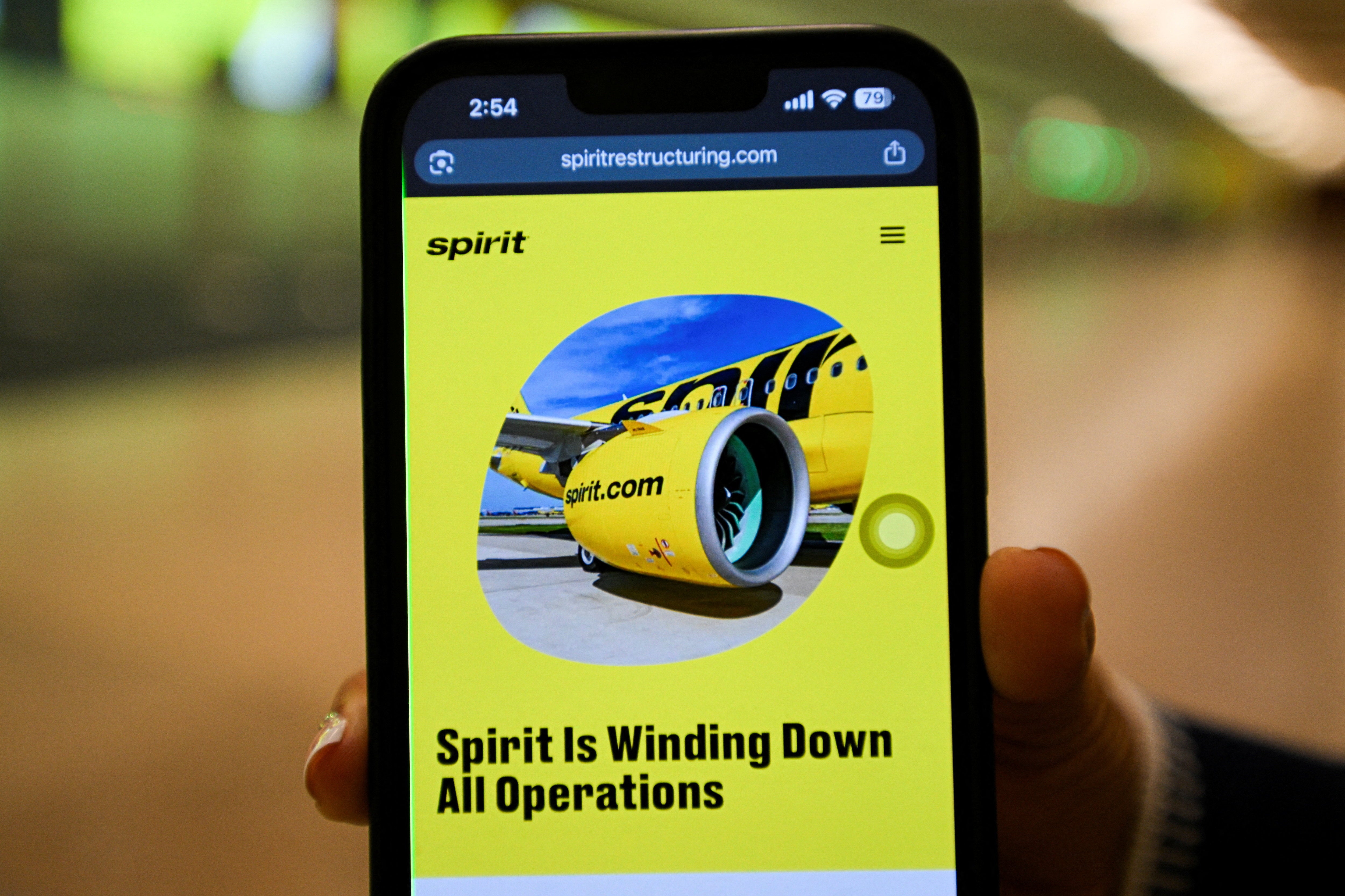 A mobile phone displays a Spirit Airlines operational update website, as the airline announced it was ceasing operations early Saturday morning