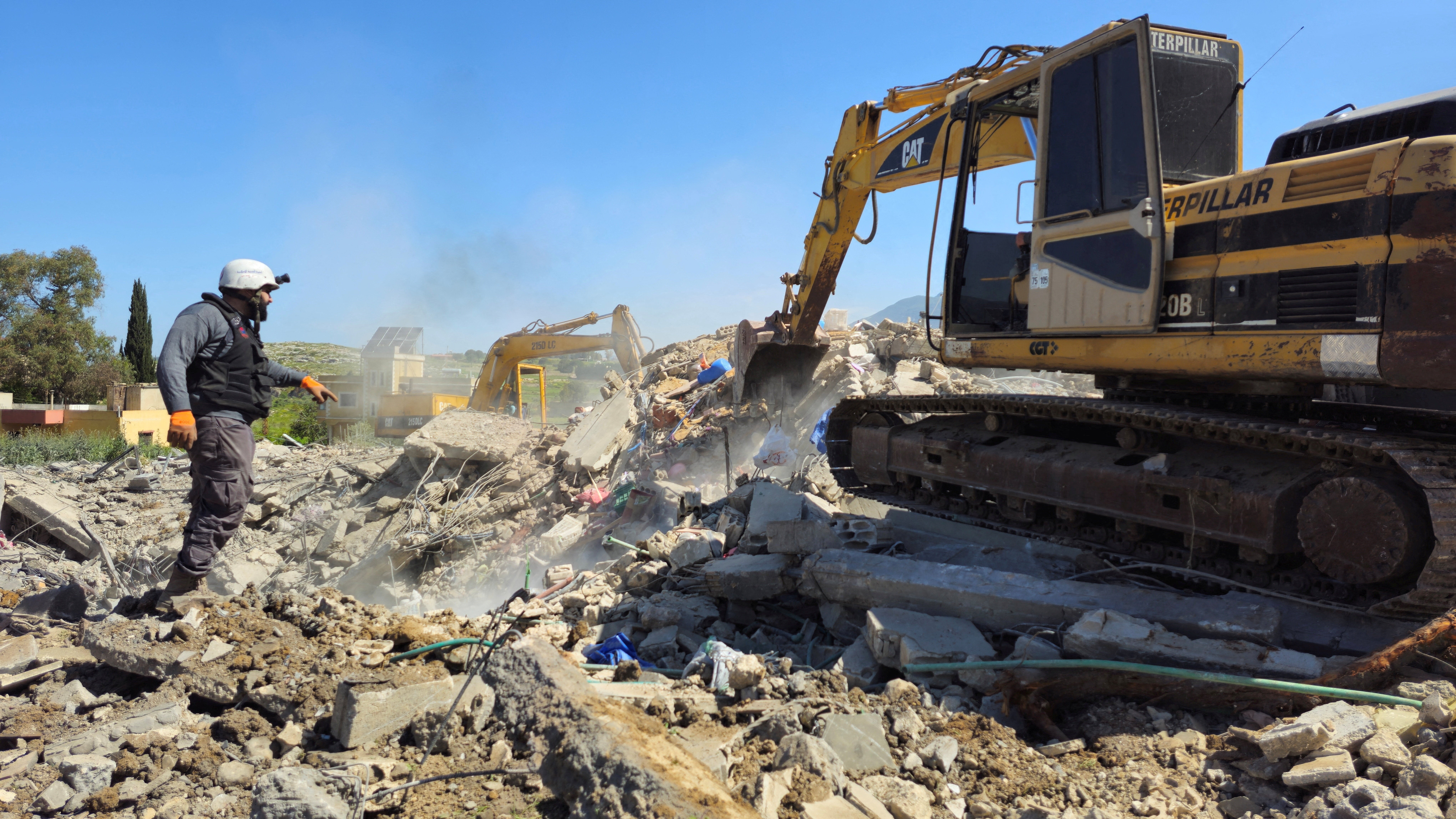 Rescue personnel clear rubble from buildings destroyed in the Lebanese town of Habboush, following Israeli strikes, Nabatieh Governorate