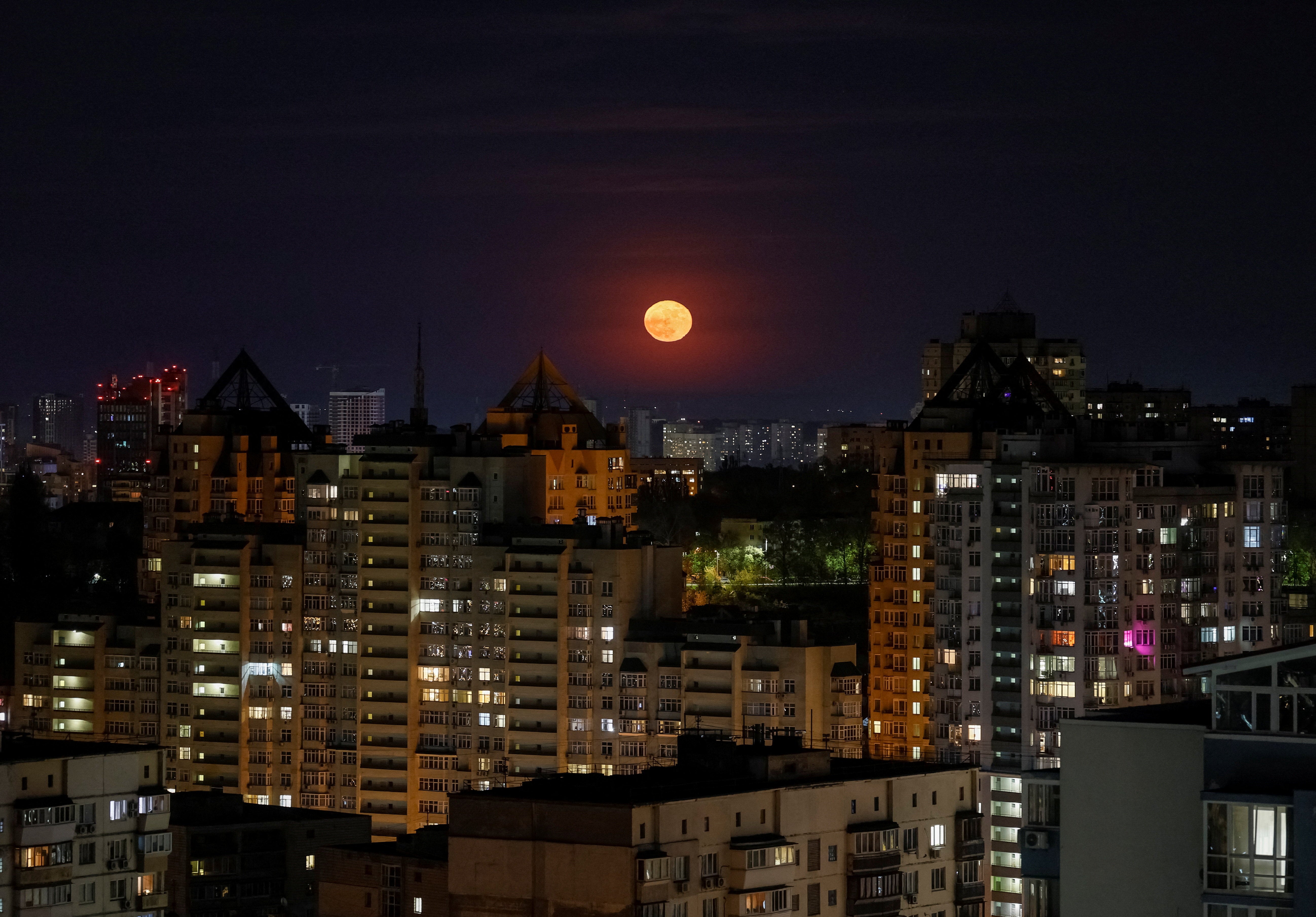 A full moon rises over the city during an air raid alarm in Kyiv