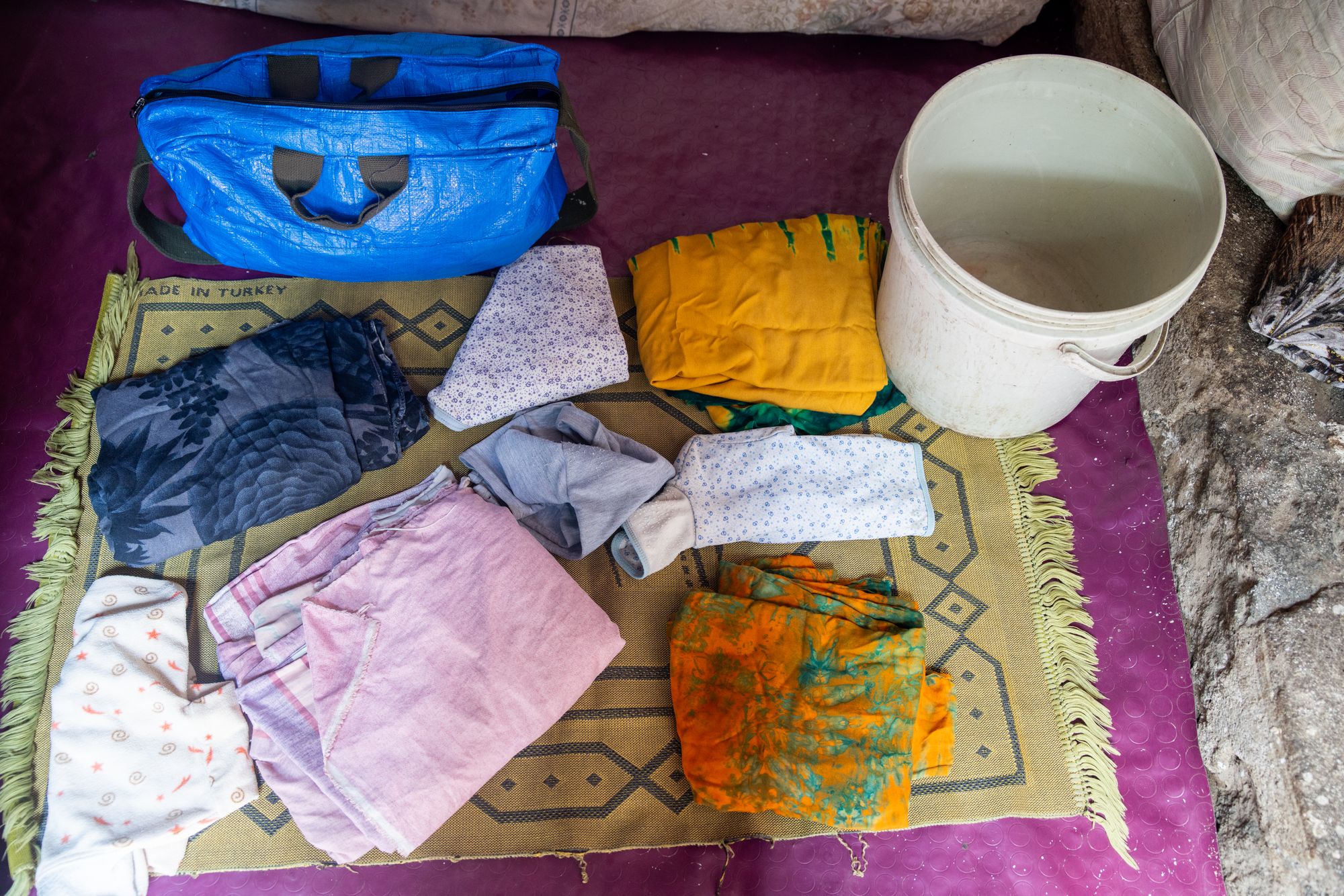 Items in Anshiya's maternity bag: bucket, used baby clothes, wrapping cloth for the baby
