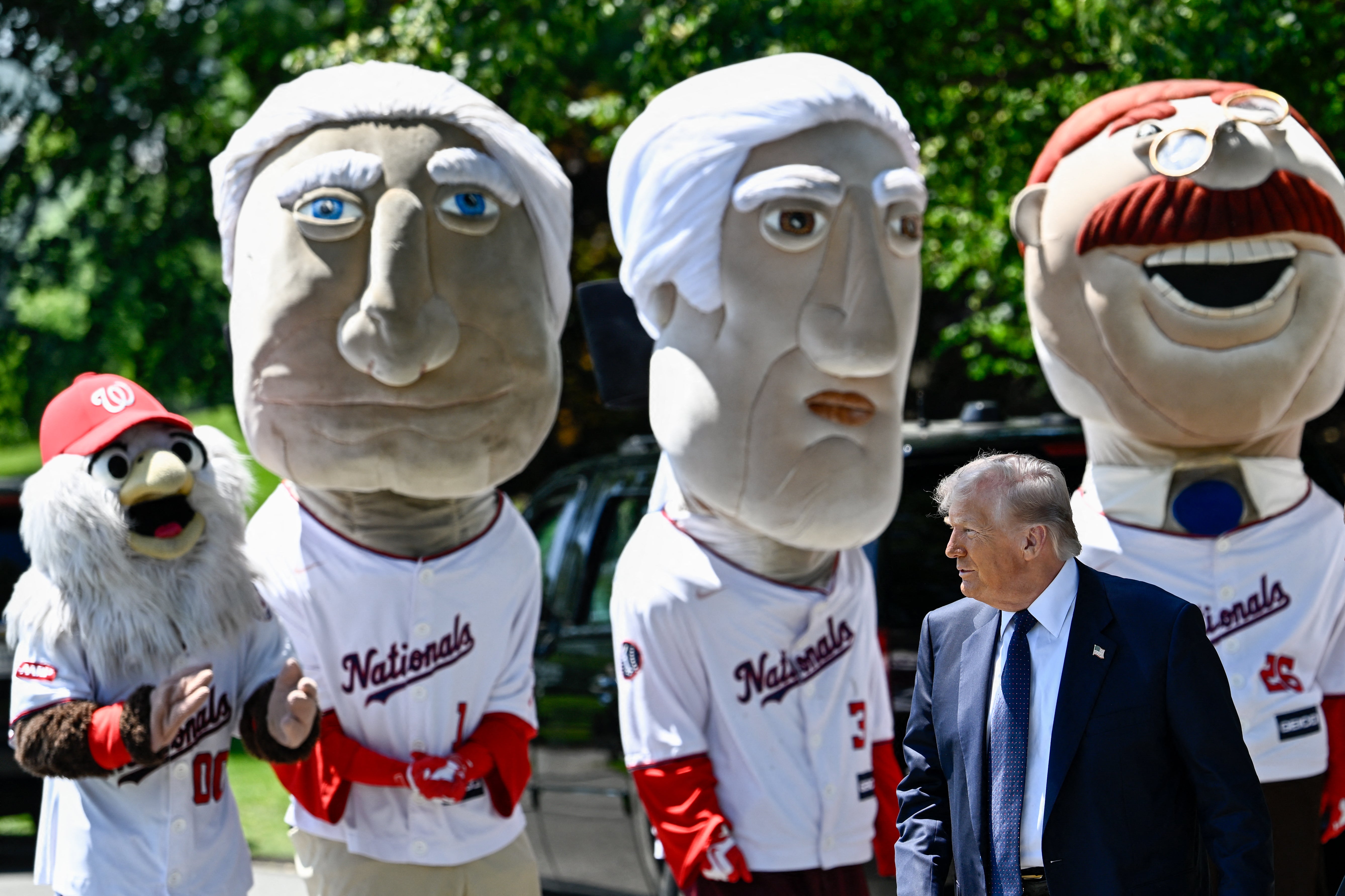 Trump surrounded by a group of mascots in Washington Nationals jerseys