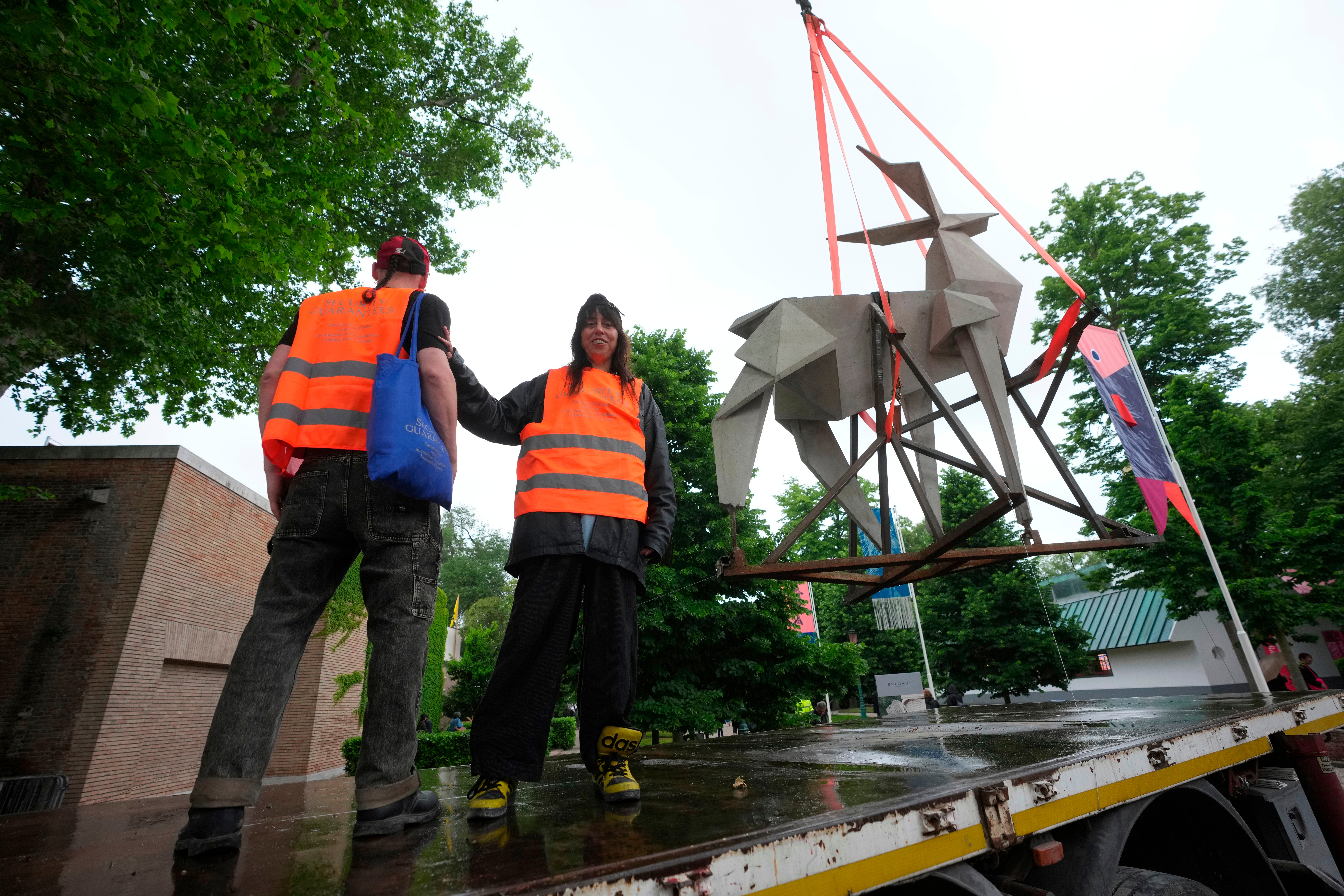 Ukrainian artist Zhanna Kadyrova poses flanked by Ukrainian artist Nikita Kravtsov next to her installation 'The Origami Deer'