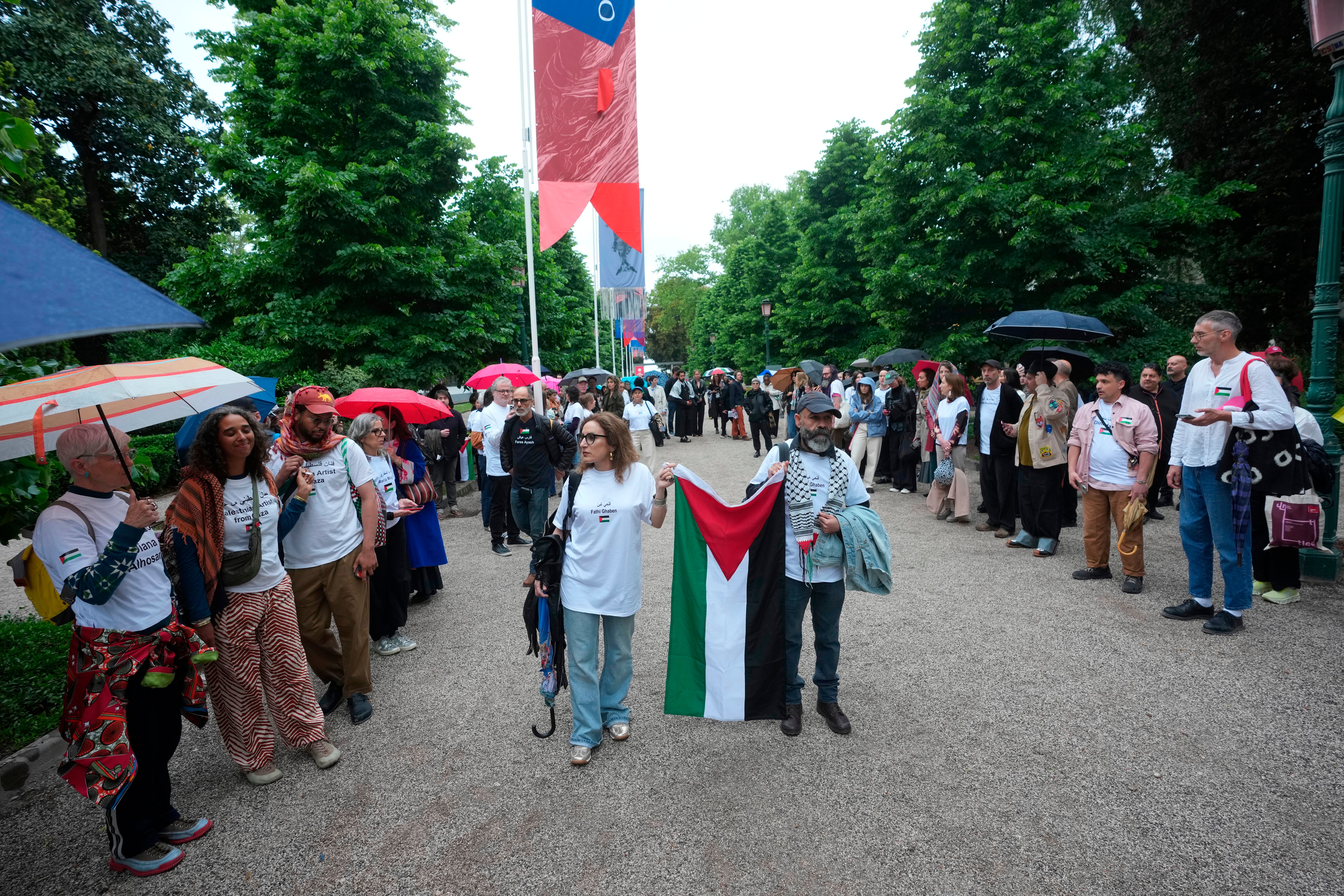 A group of Palestinians gather in front of the main entrance wearing the names of artists who have been killed in Gaza.