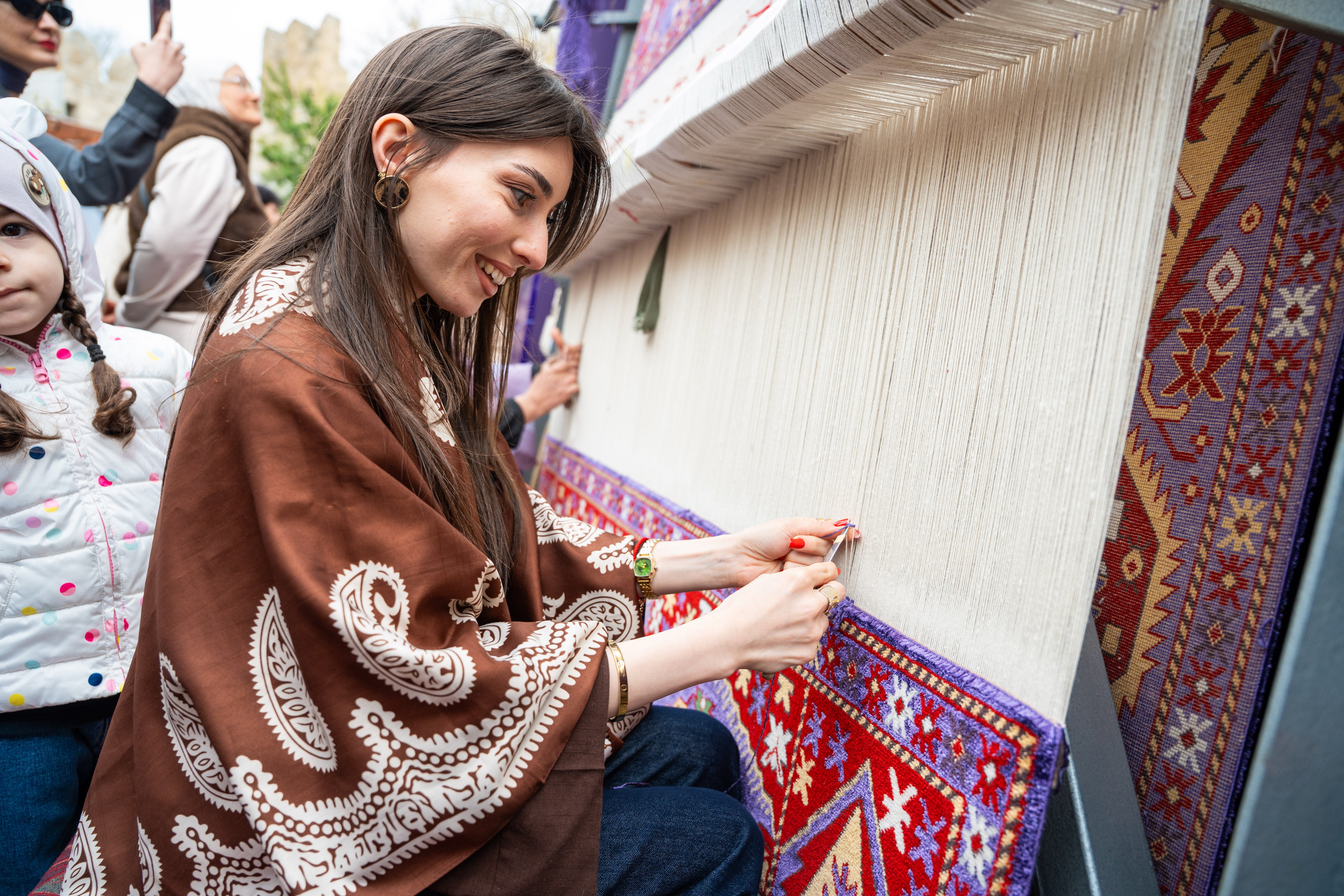 A woman weaves at the International Carpet Festival