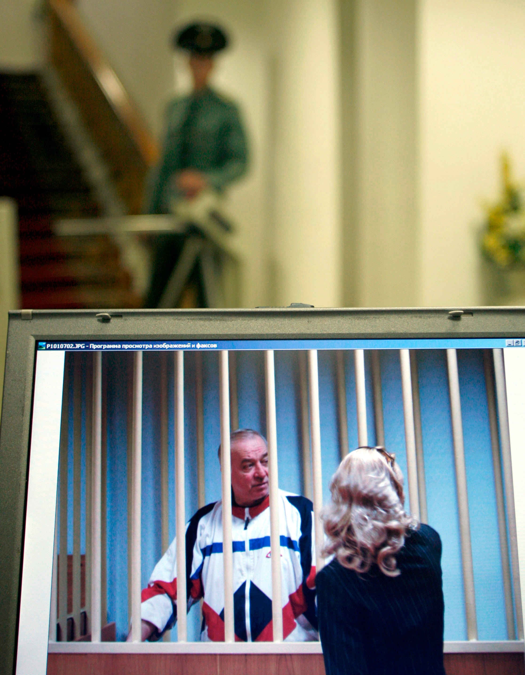Sergei Skripal, left, is seen on a screen speaking to his lawyer from behind bars in Moscow on Aug. 9, 2006