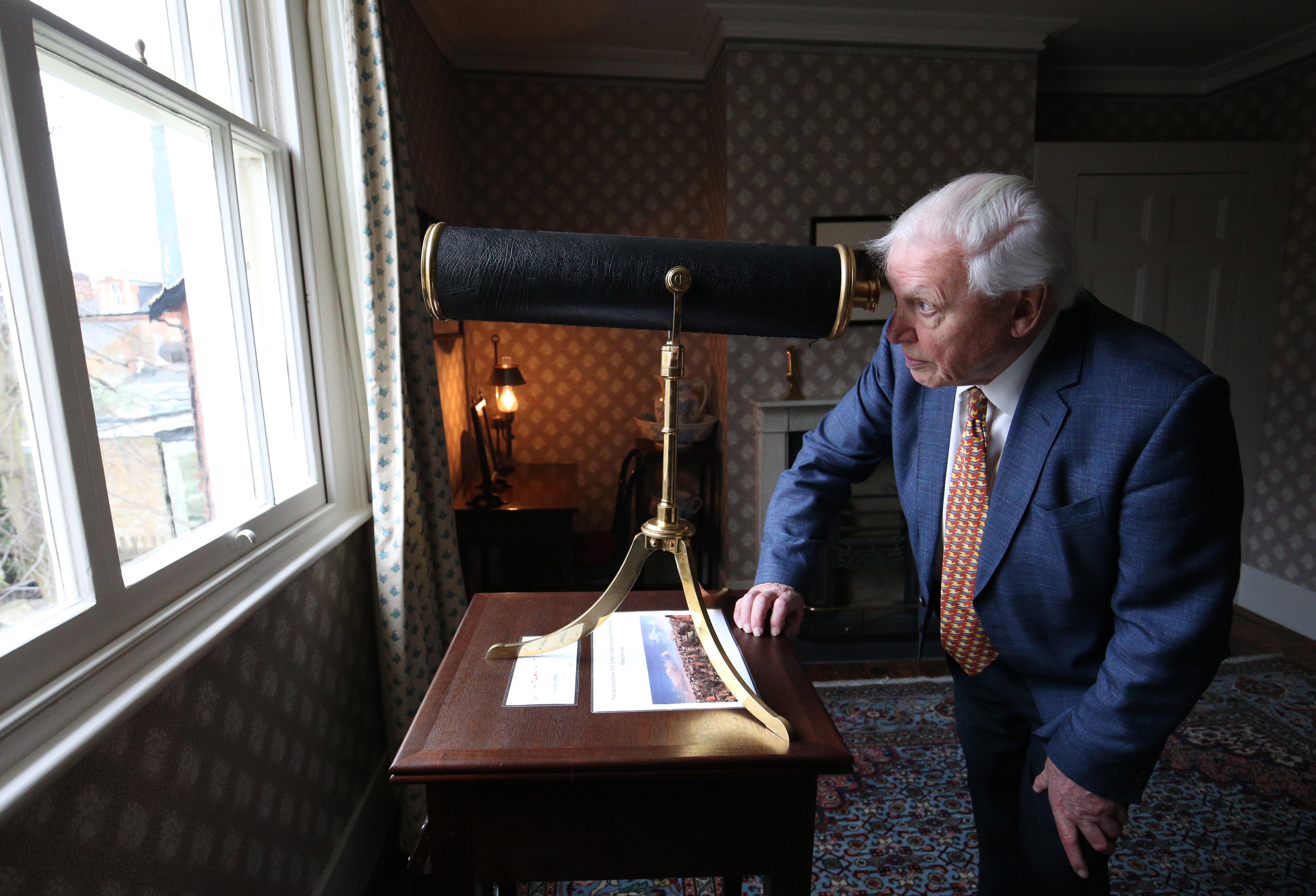 Sir David Attenborough olha através de um telescópio no quarto de JMW Turner.