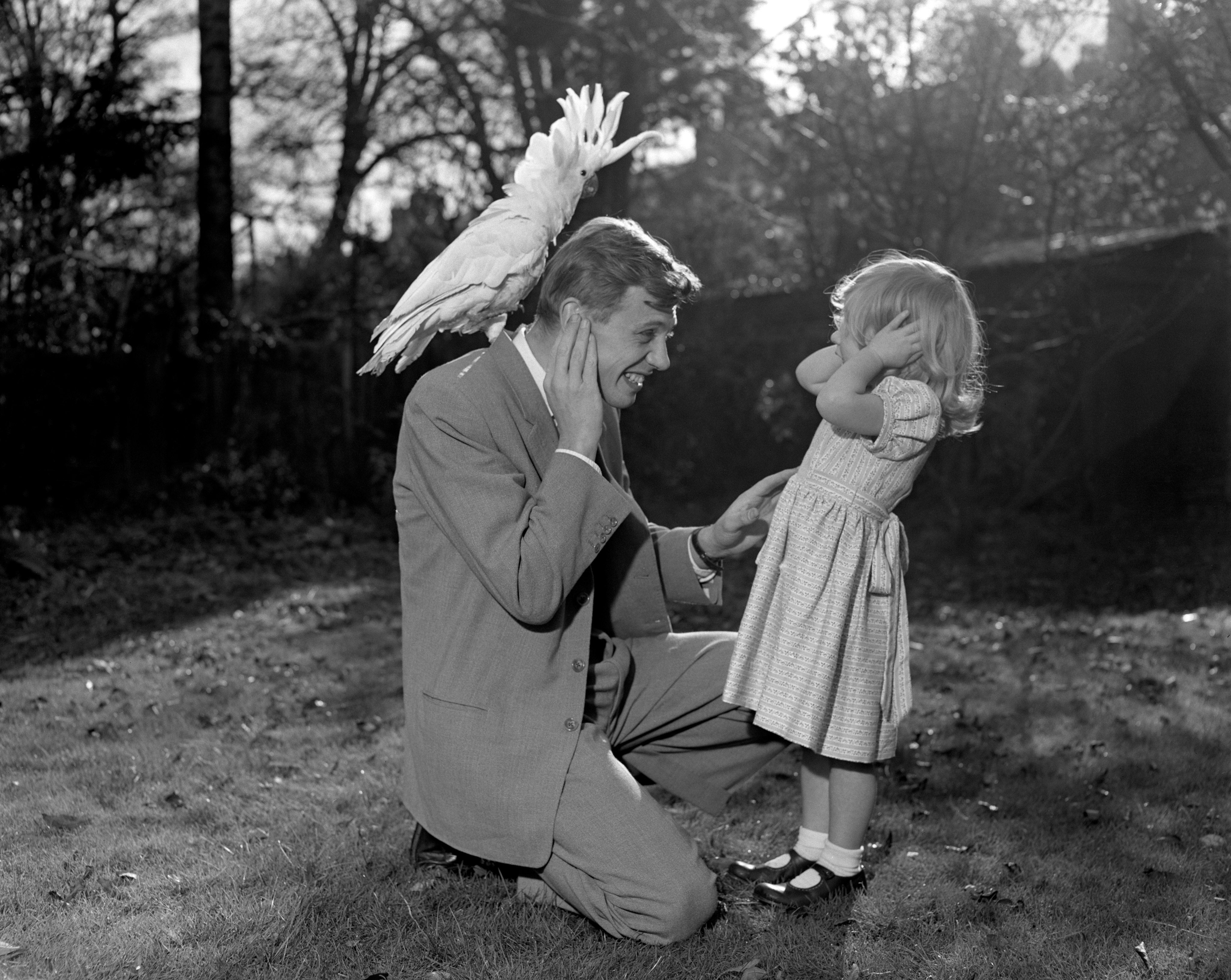 Susan e seu pai David Attenborough cobrindo com a cacatua Georgie com crista de enxofre.