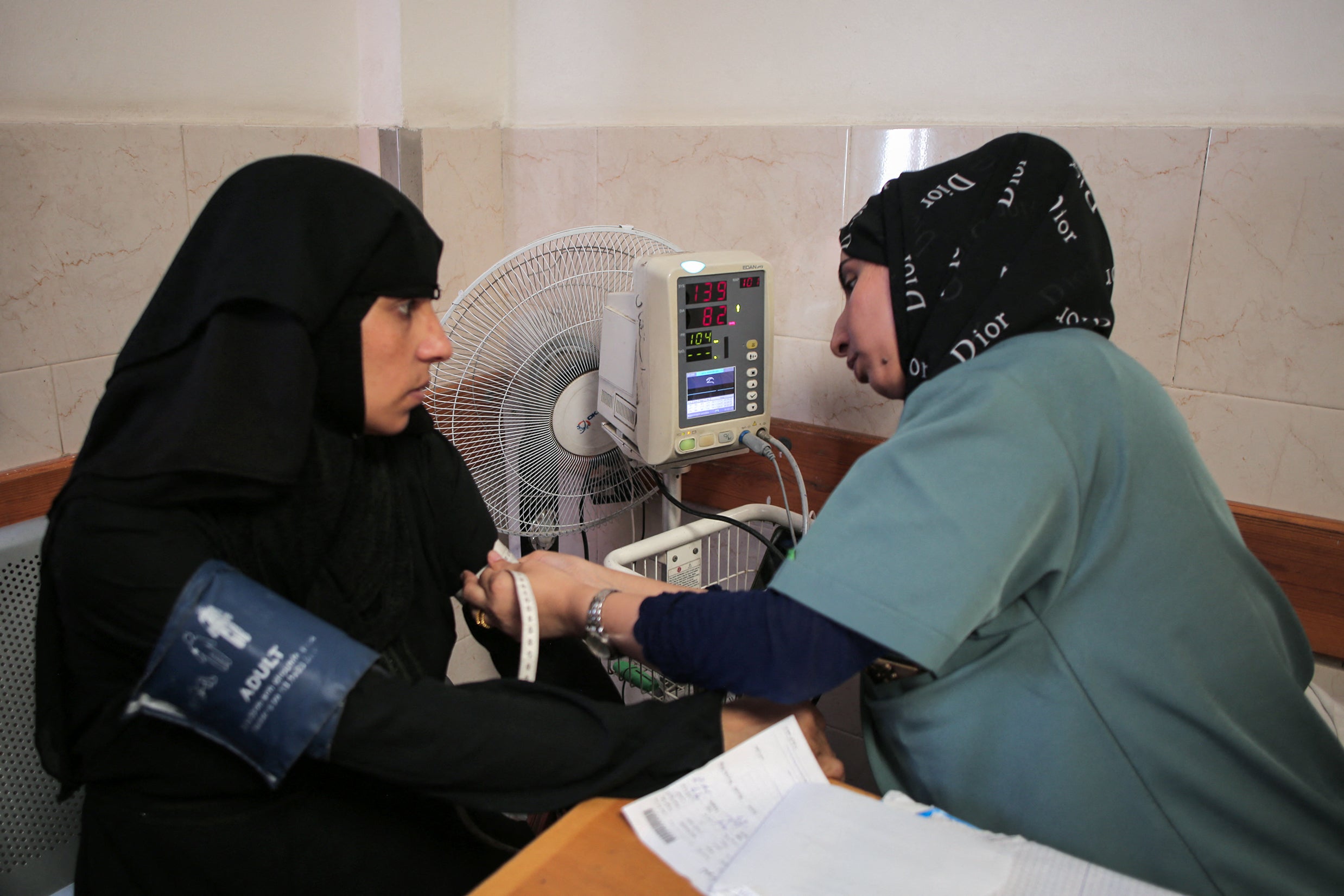 A Palestinian medic examines a woman at a maternity clinic in Khan Younis