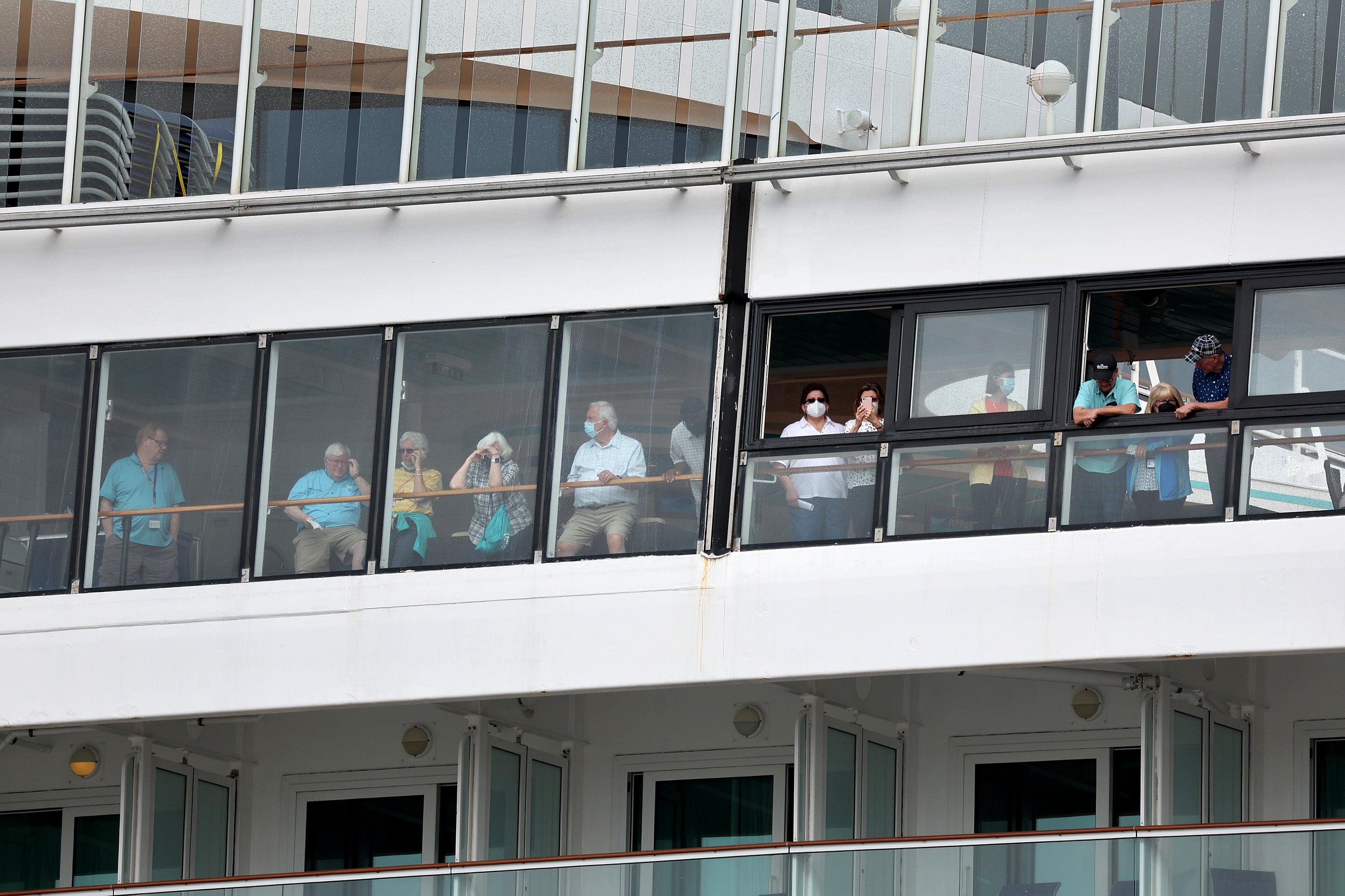 Passengers wait on the Covid-stricken Norwegian Pearl cruise ship at Port Miami in January 2022. Cruise ships helped Covid to spread during the pandemic