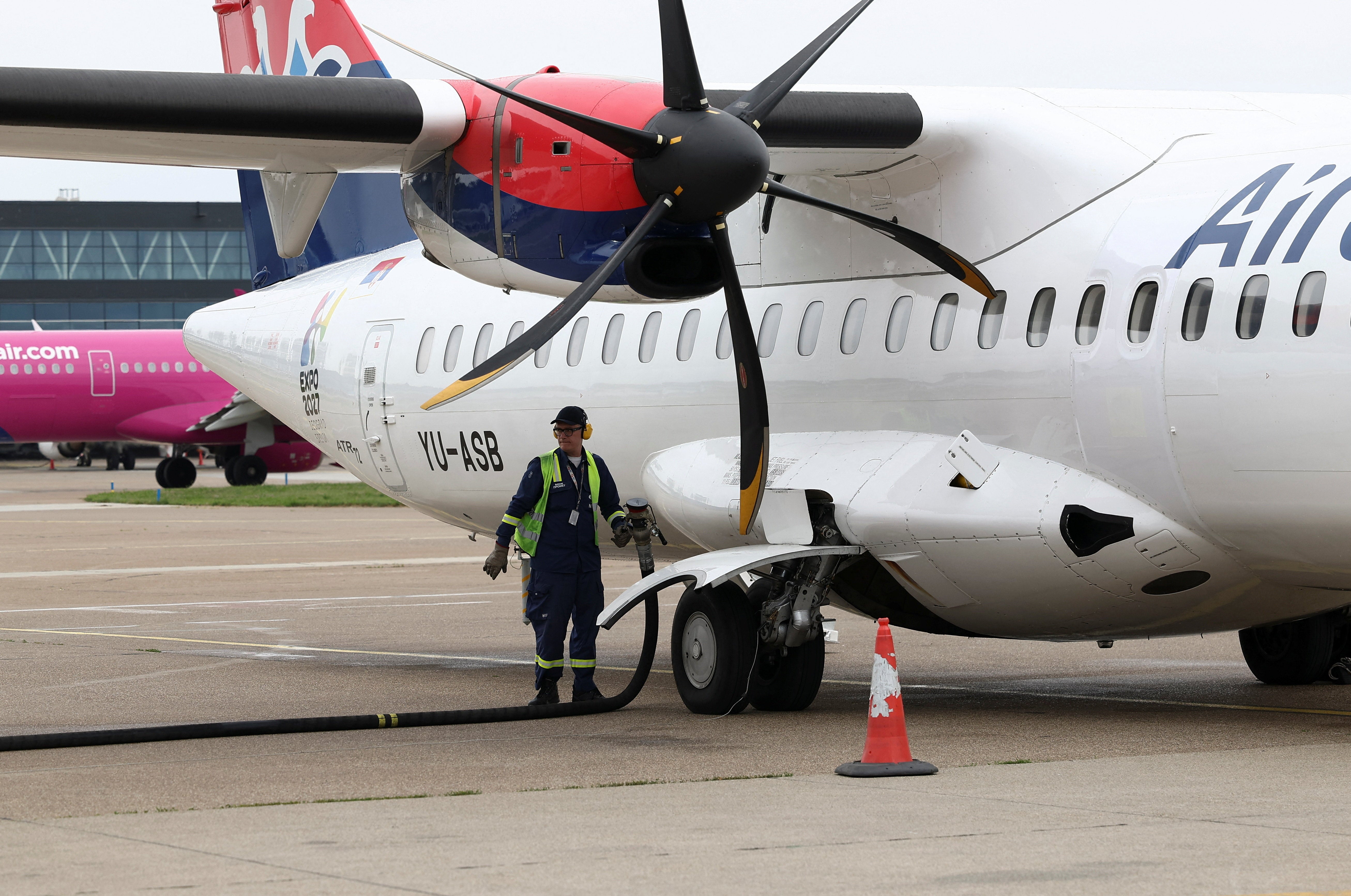 A worker refuels a plane at Belgrade Nikola Tesla airport as airports across Central and Eastern Europe are bracing for potential jet fuel shortages and flight disruptions linked to the Middle East crisis, in Belgrade, Serbia