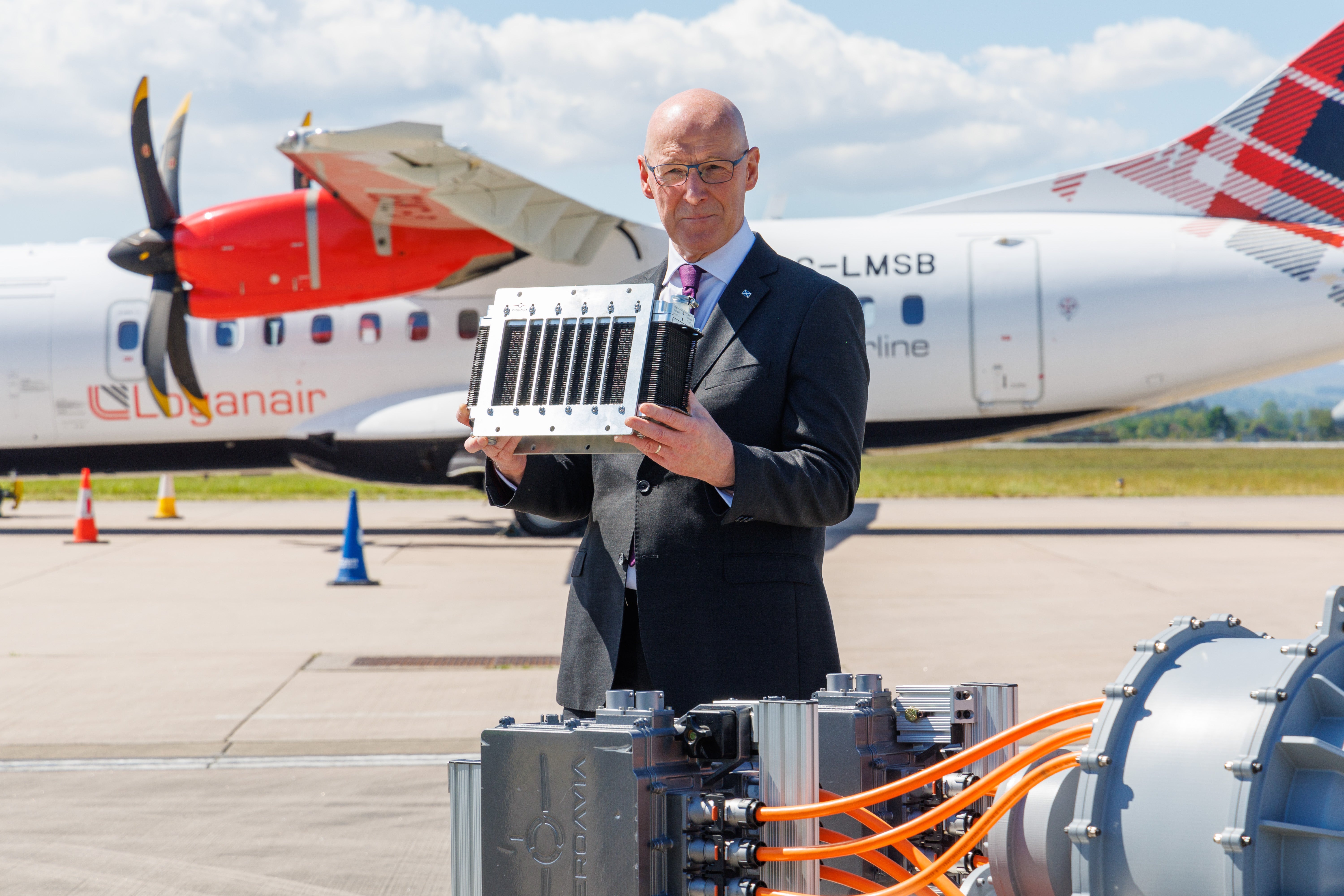 First Minister John Swinney holds a hydrogen cell during a visit to Glasgow airport