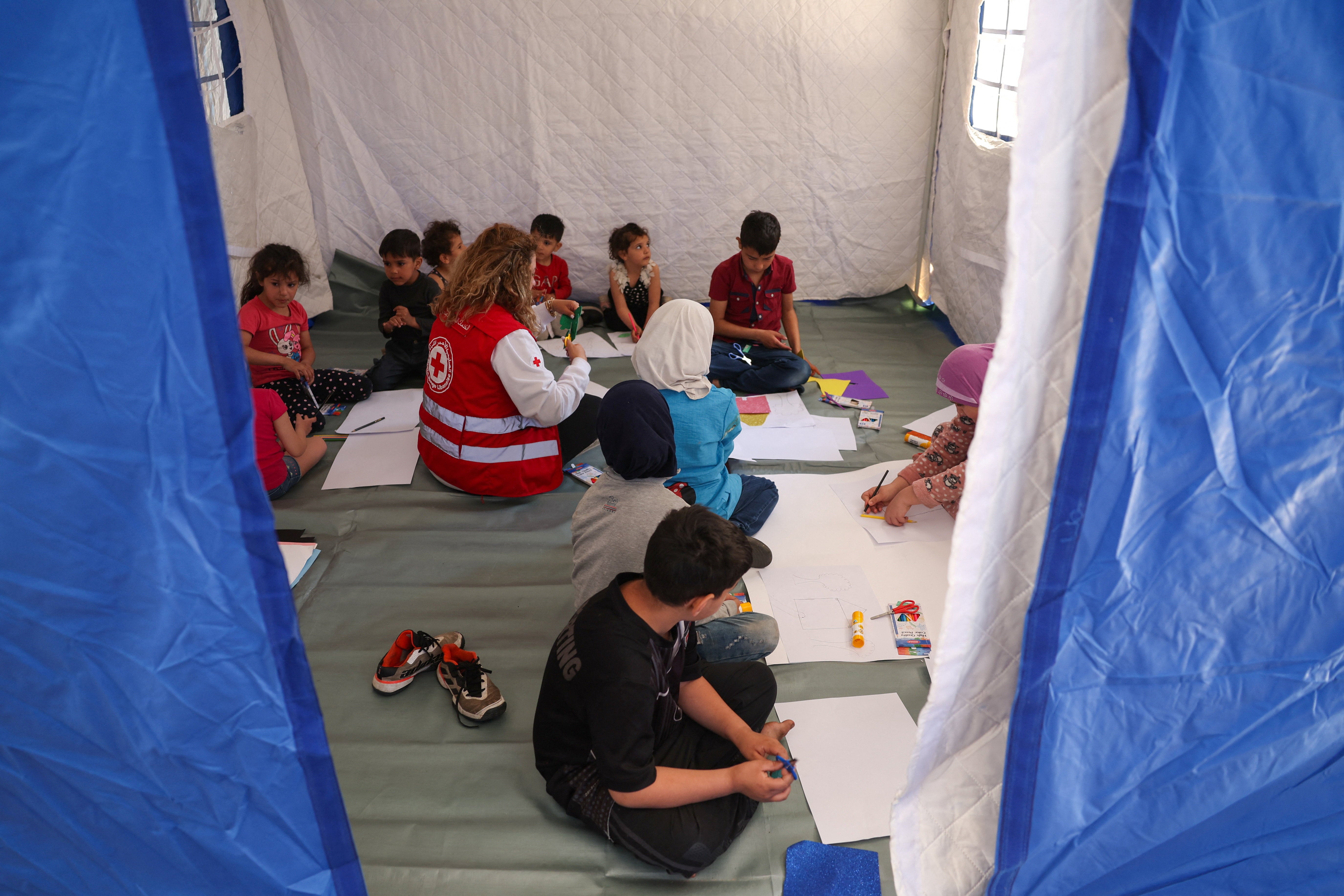 A member of the Red Cross provides learning activities to children inside a tent at Camille Chamoun Sports City stadium turned into a temporary shelter in Beirut, Lebanon, May 8