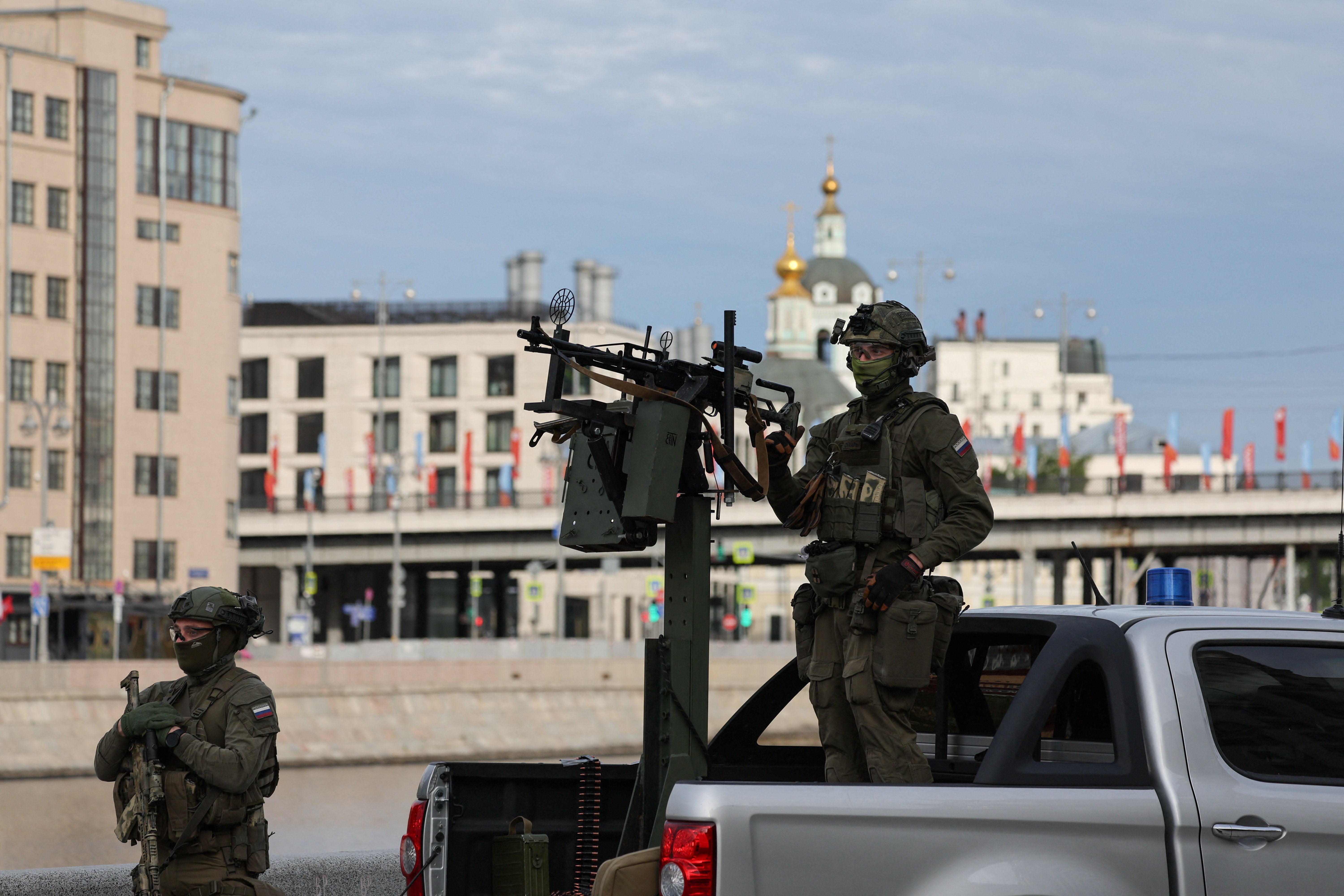 Russian security personnel patrol an area on a pickup truck armed with a machine gun amid increased security measures taken before a military parade on Victory Day