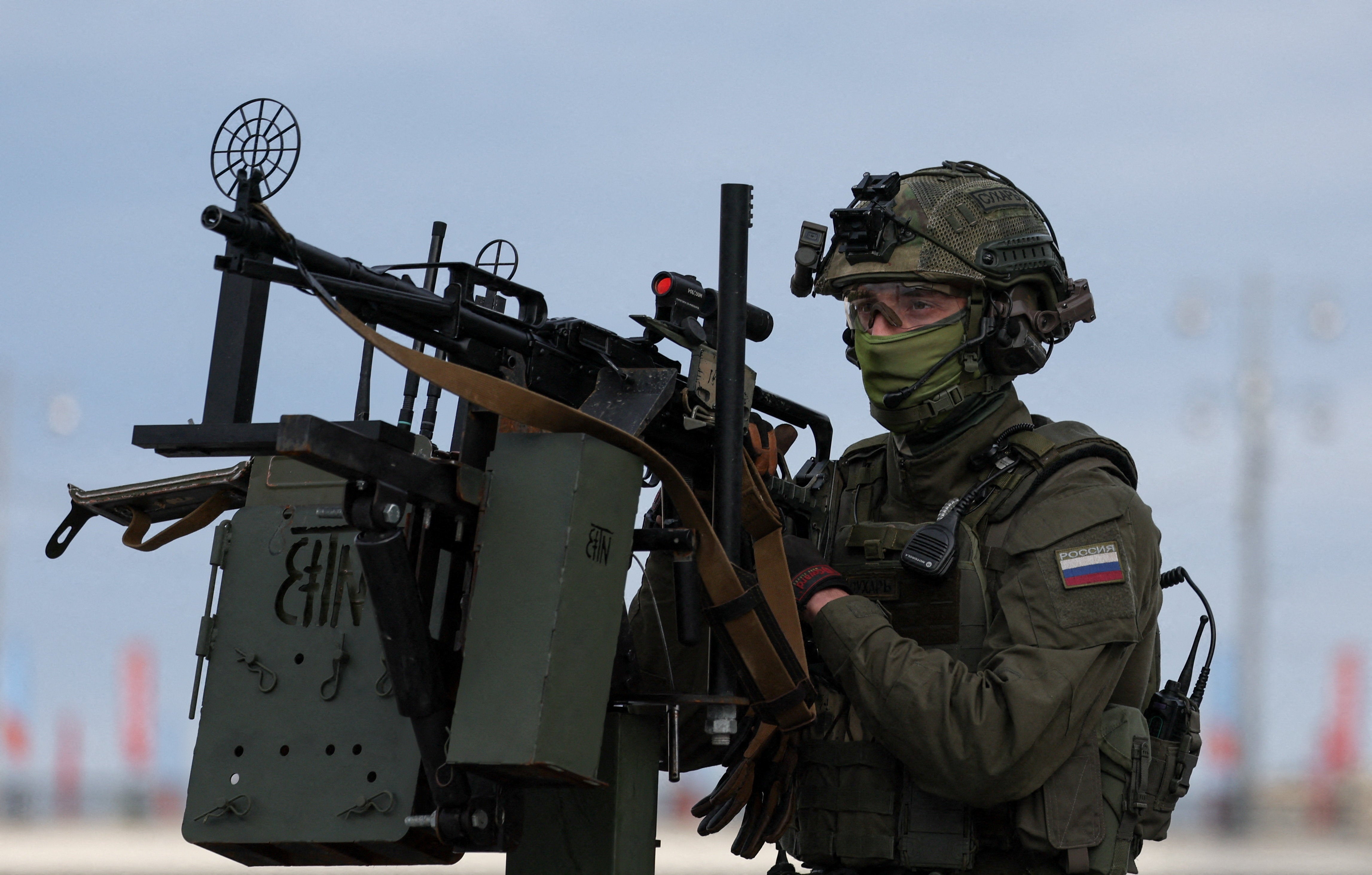 A security guard stands atop a pickup truck armed with a machine gun while patrolling an area amid increased security measures taken before a military parade on Victory Day