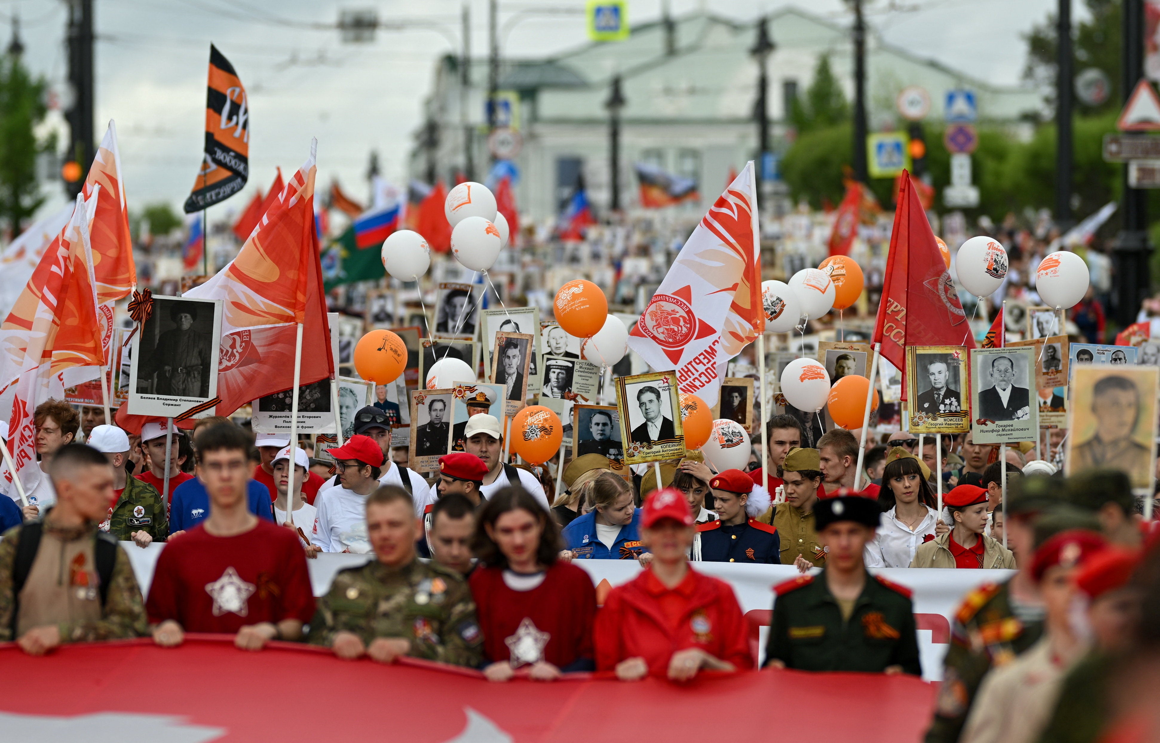 Participants carry portraits of people, including Red Army soldiers and veterans, during the Immortal Regiment march on Victory Day