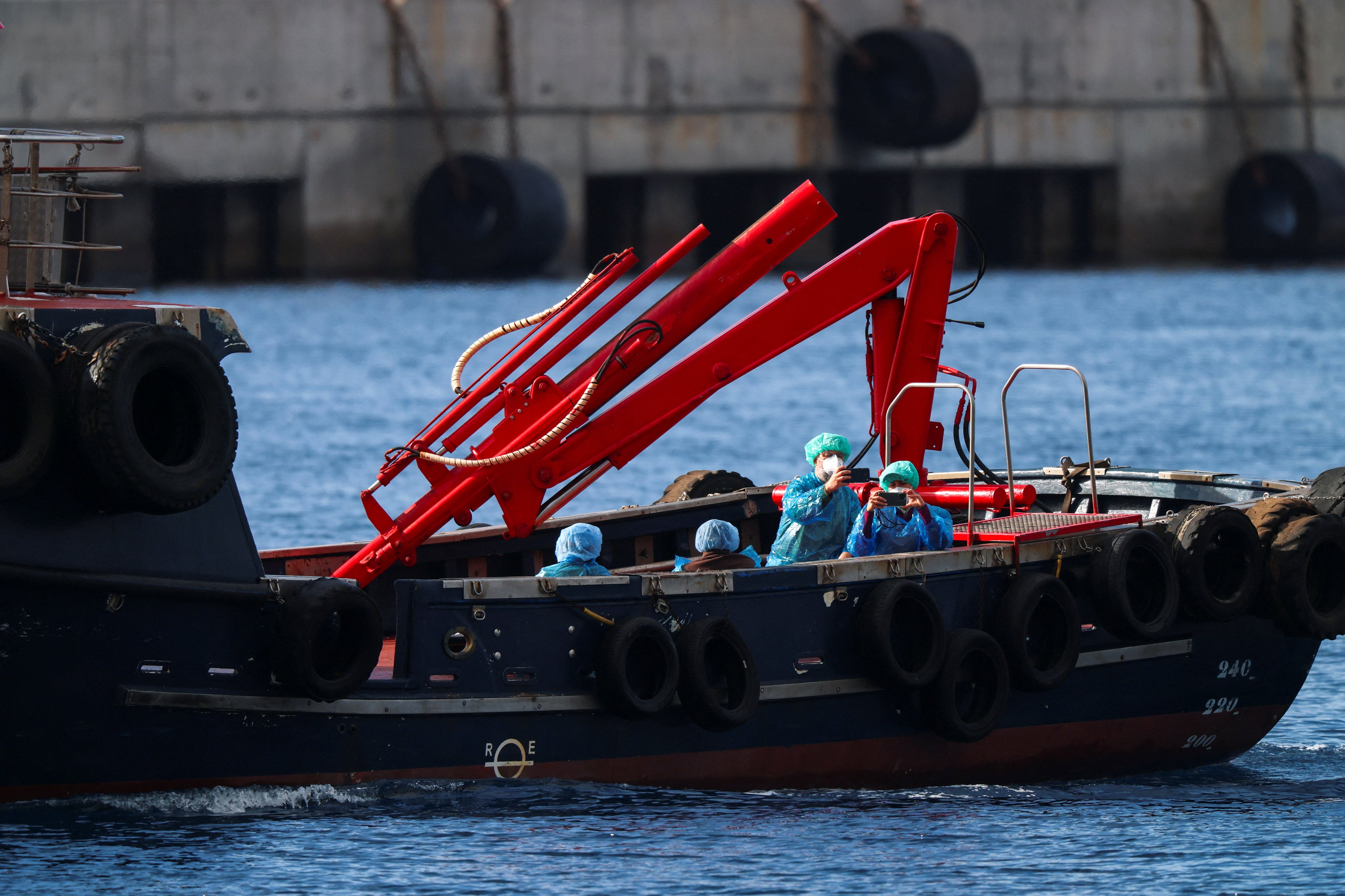 People from the cruise ship MV Hondius, affected by a hantavirus outbreak, are transferred by boat to the port after disembarking