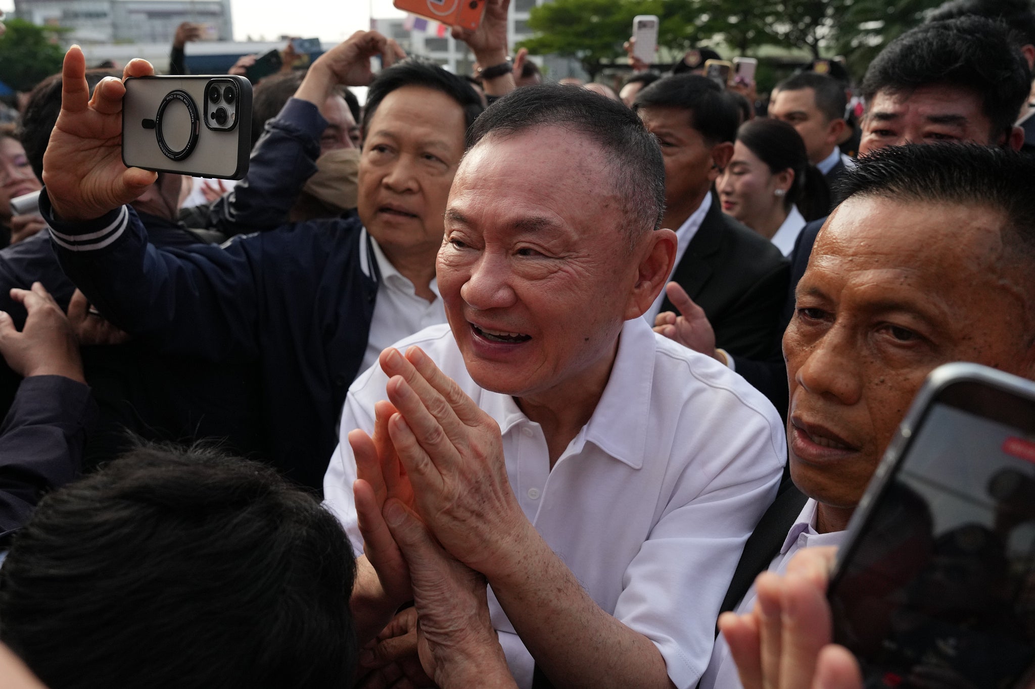 Thaksin Shinawatra, center, gestures to supporters following his release on parole from a Bangkok prison in Thailand on 11 May 2026