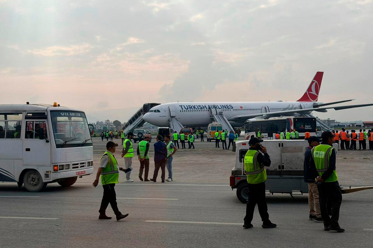 A Turkish Airlines aircraft is seen after passengers were safely evacuated and Nepal's main airport shut down, following a fire on the jet while landing in Kathmandu, Monday, May 11, 2026. (AP Photo/Rajneesh Bhandari)