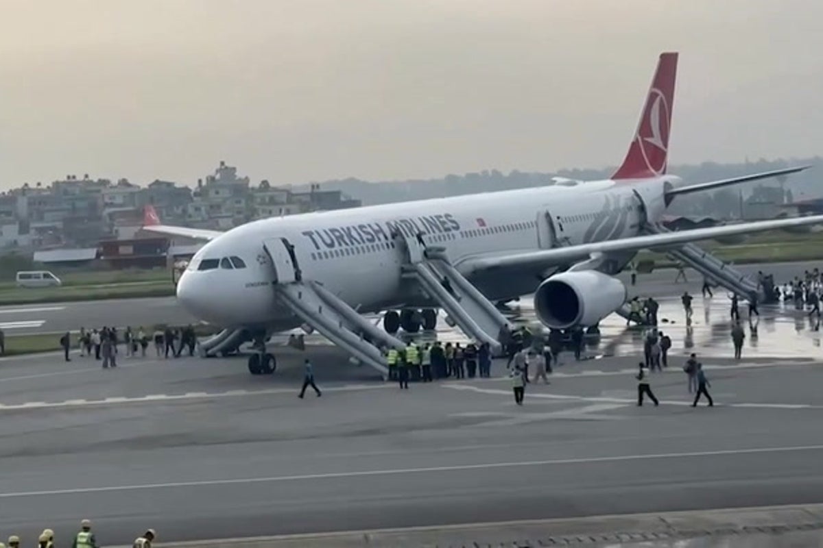 Turkish Airlines passengers evacuate on emergency slides after plane catches fire
