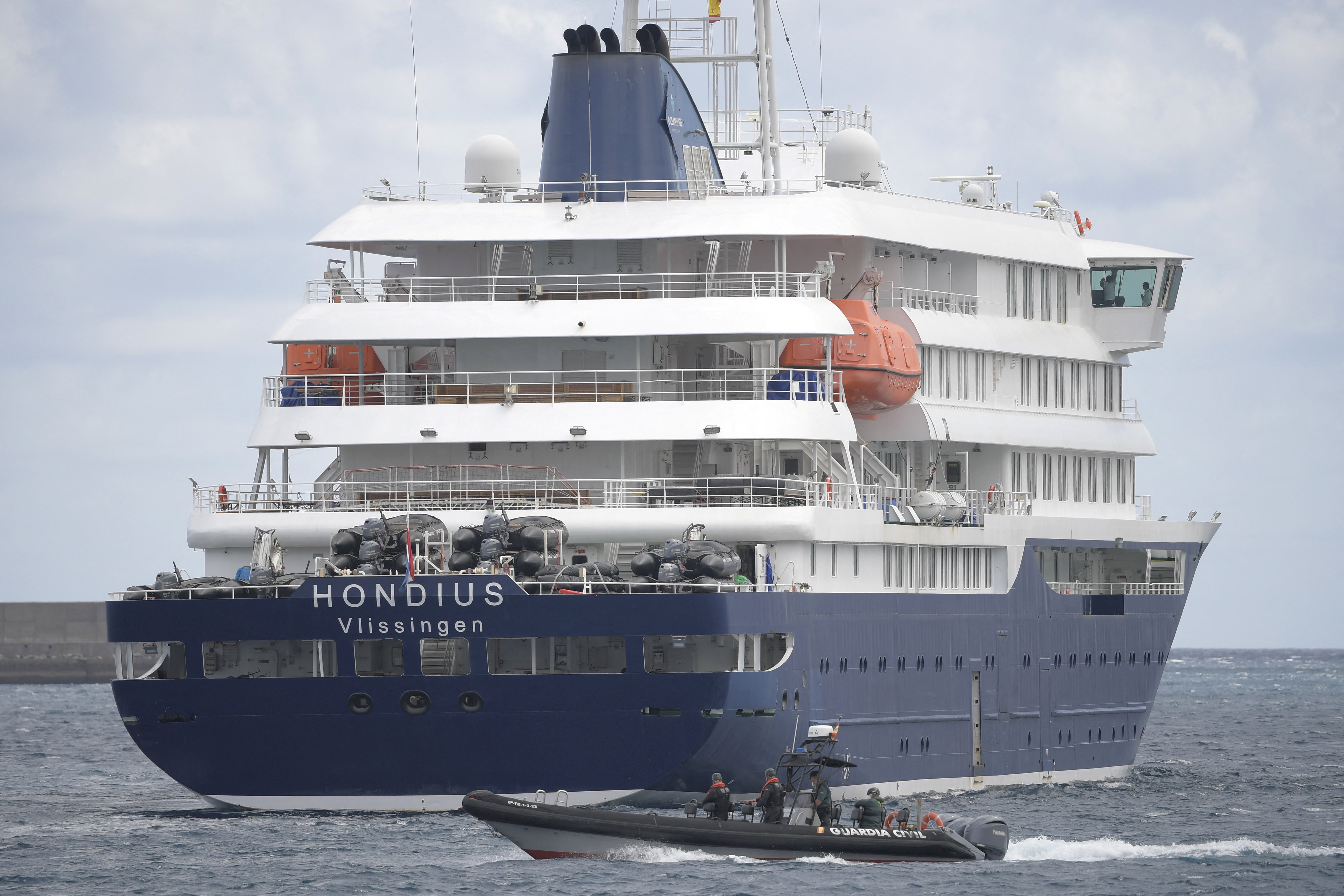 A Spain's Guardia Civil boat sails next to Dutch flagged hantavirus-stricken cruise ship MV Hondius in the port of Granadilla de Abona on the island of Tenerife in Spain's Canary Islands on 11 May 2026