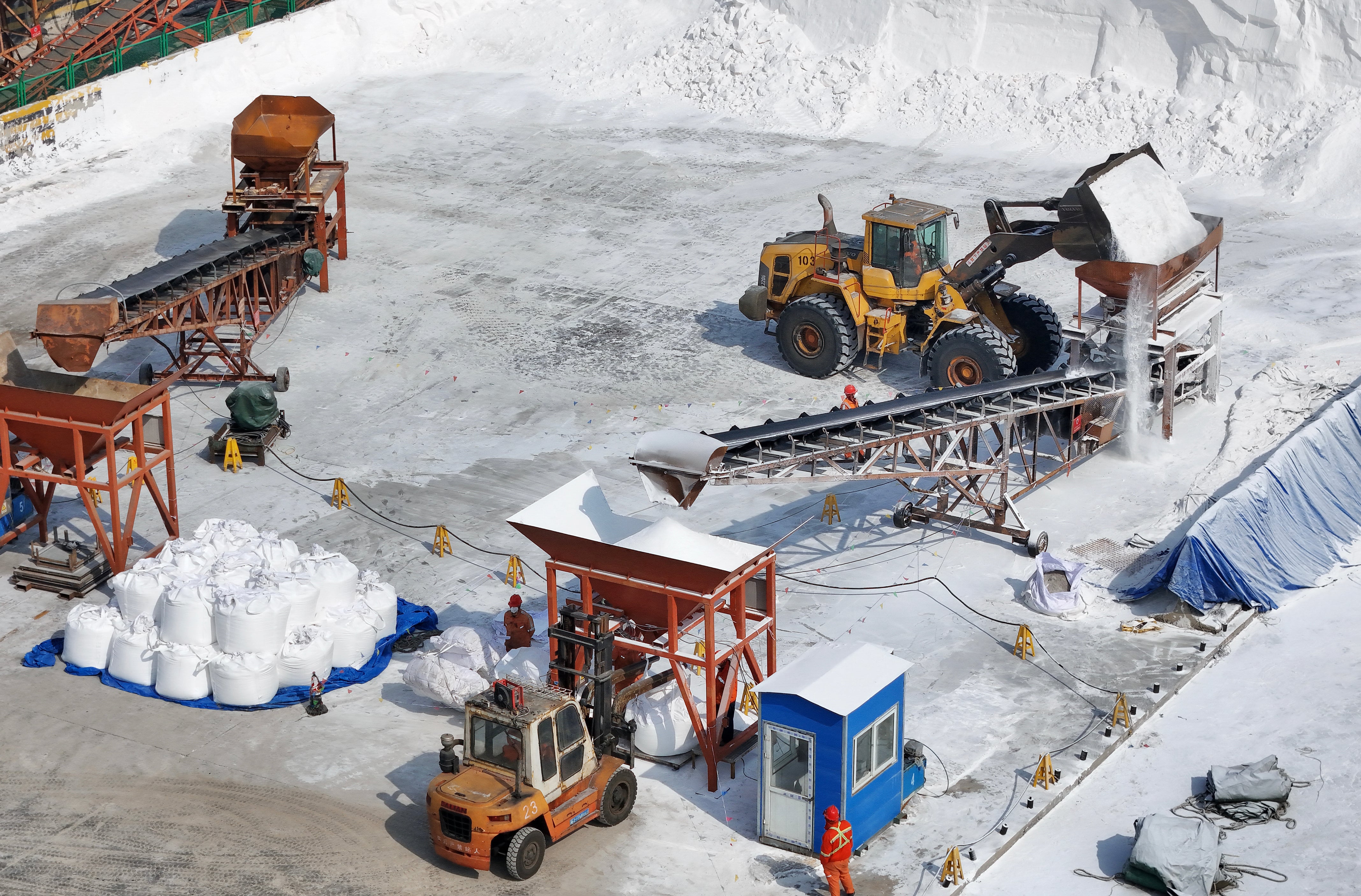 Workers bag urea fertiliser for export at a port in China's eastern Shandong province