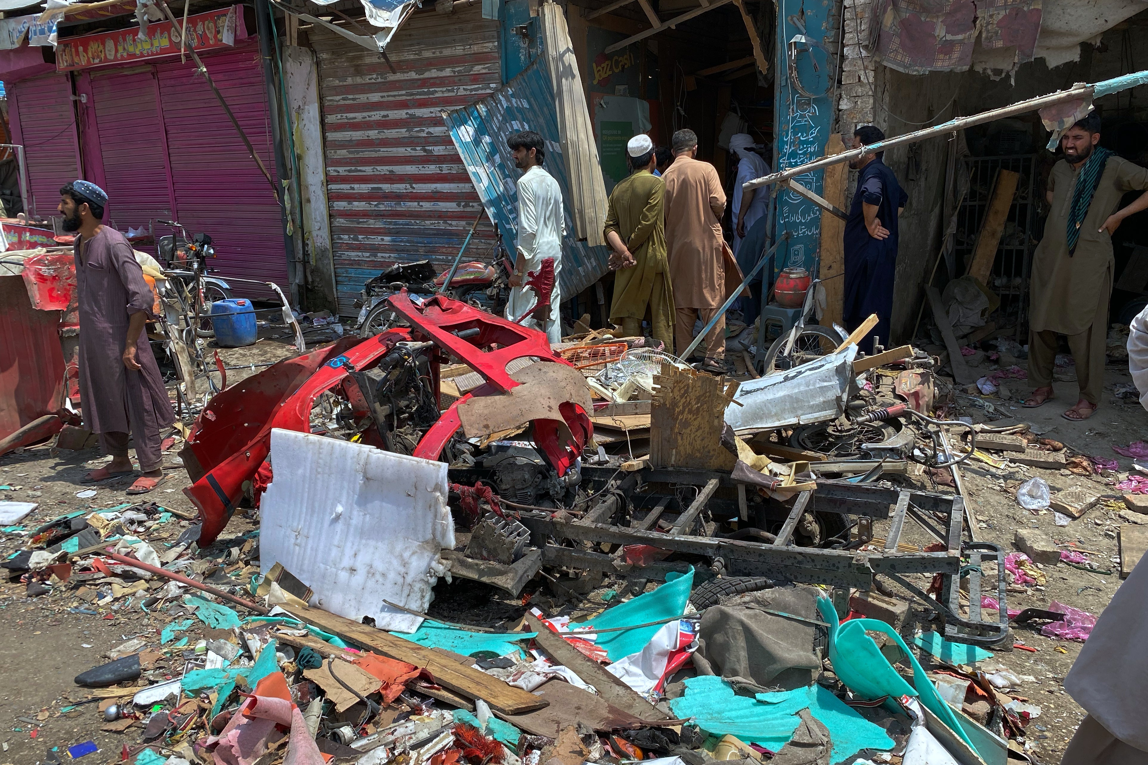 Local residents examine damage at the site of a bomb explosion at a market in Lakki Marwat, a district in Pakistan's Khyber Pakhtunkhwa province