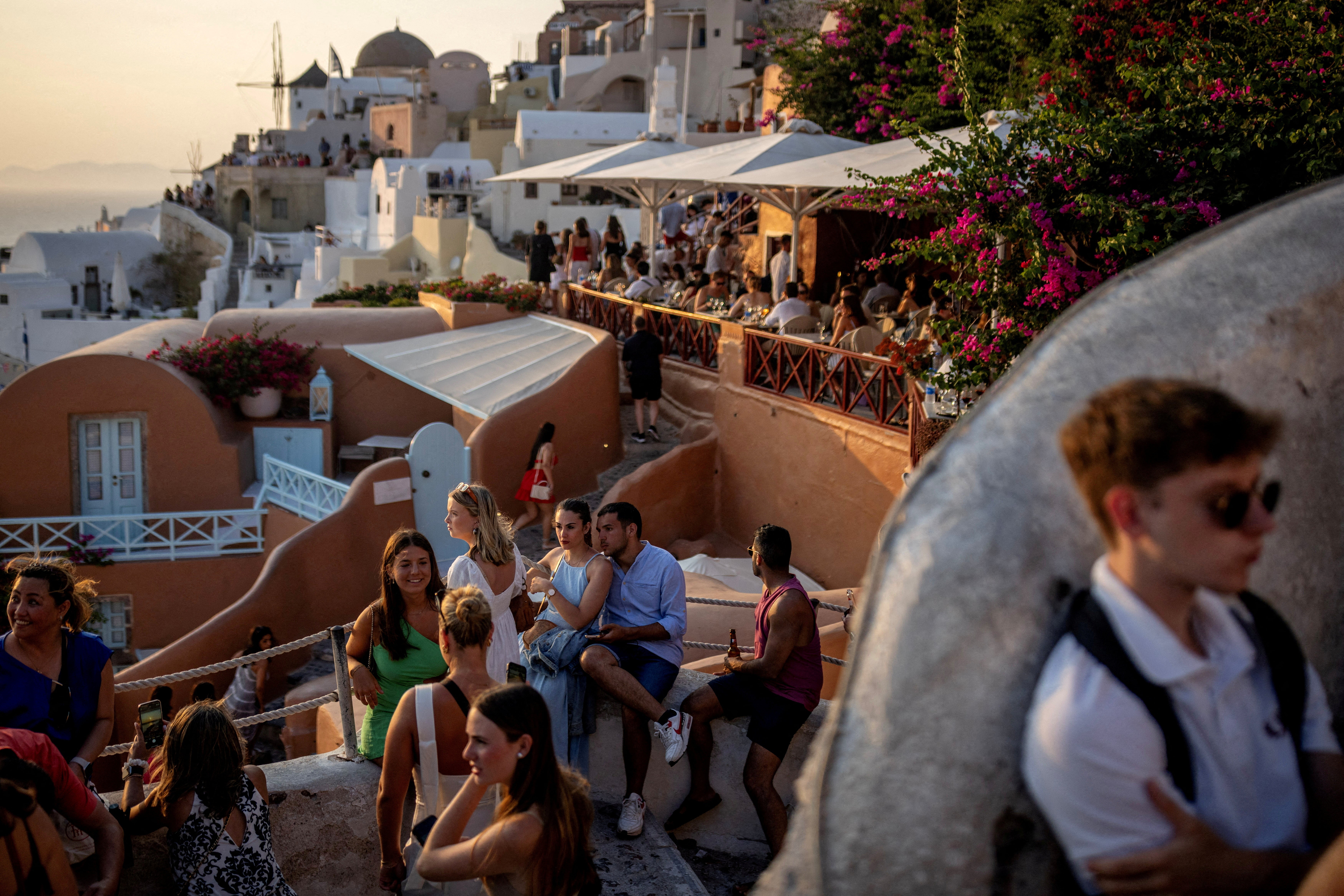 Tourists wait to view Santorini’s famed sunset, on Santorini, Greece
