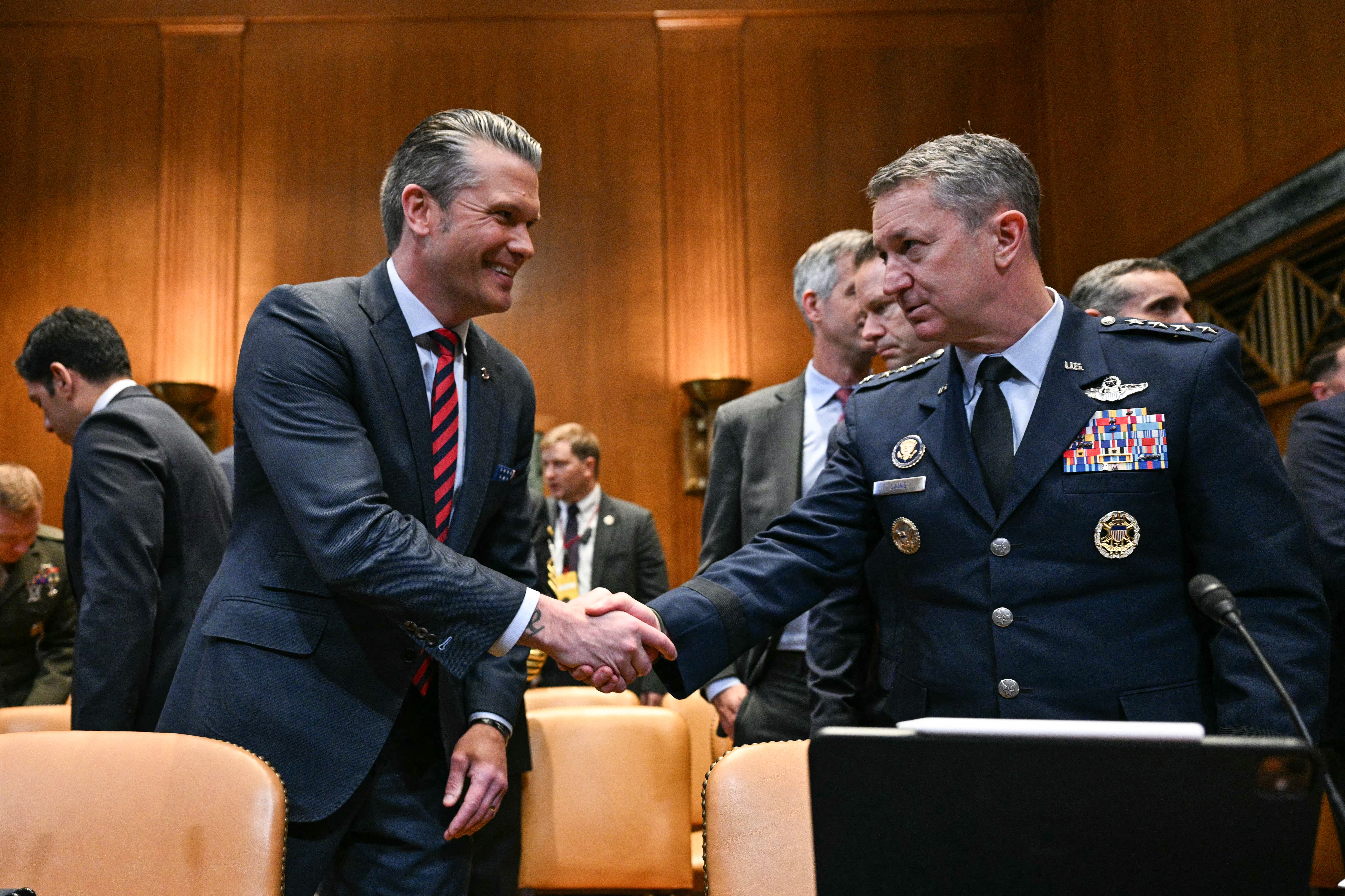 Hegseth and Caine shake hands as they prepare to testify before the Senate Appropriations Subcommittee on Defense