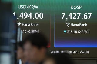 Screens showing Korea Composite Stock Price Index and foreign exchange rates at Hana Bank in Seoul, South Korea