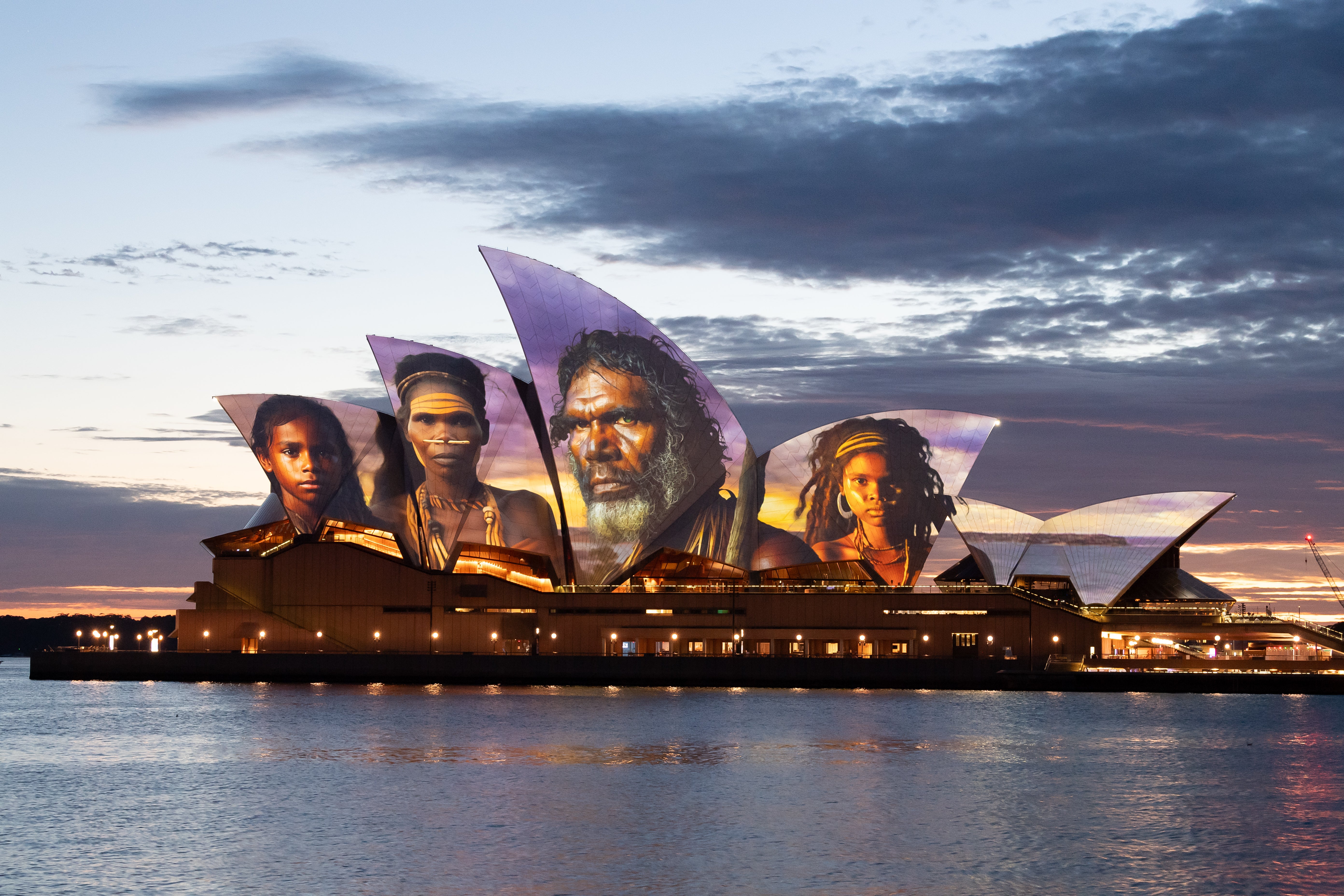 The sails of the Sydney Opera House are illuminated by a projection of indigenous artwork by Indigenous artist Brett Leavy