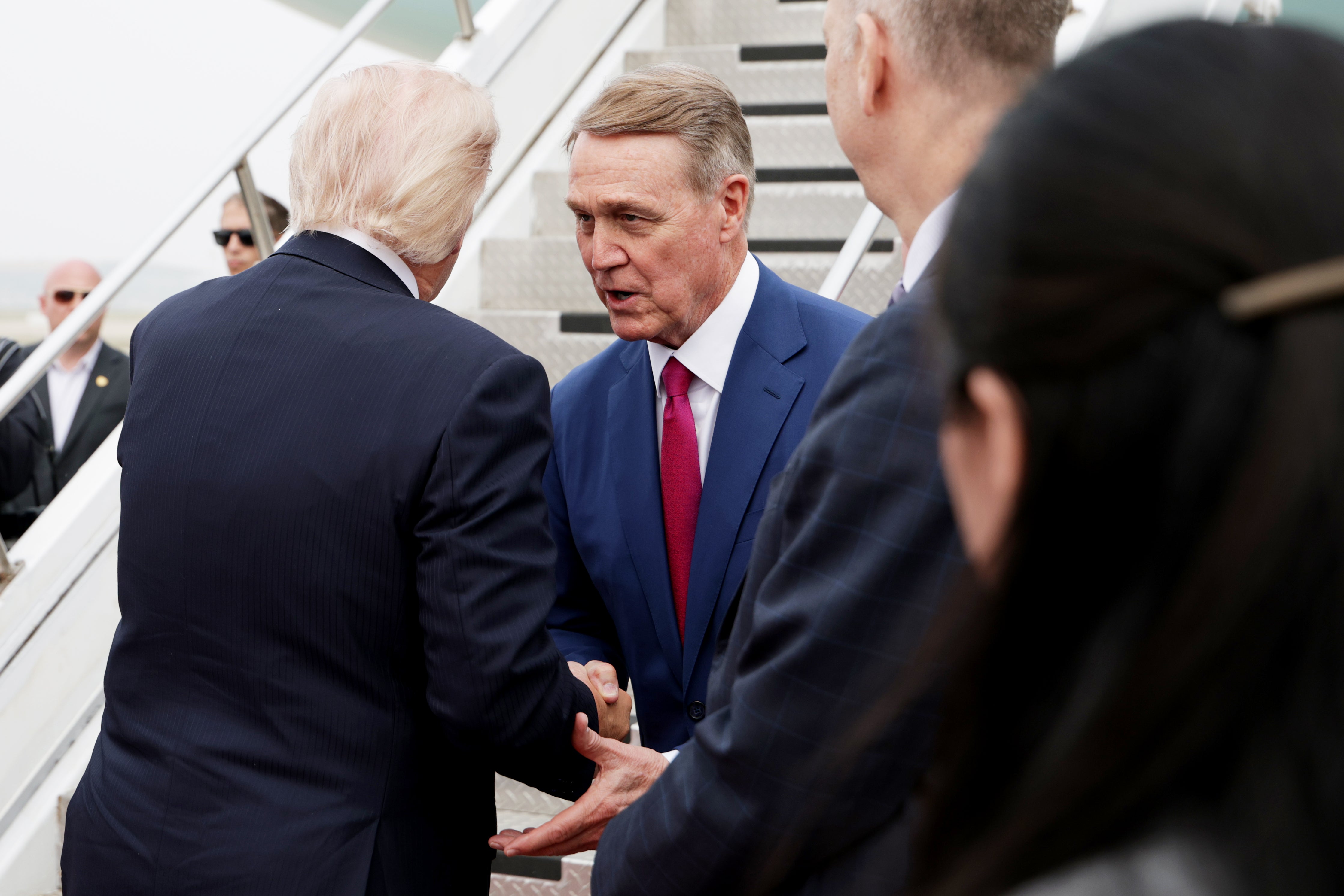 US president Donald Trump shakes hands with Ambassador to China David Perdue as he prepares to board Air Force One at Beijing Capital International Airport (Getty)