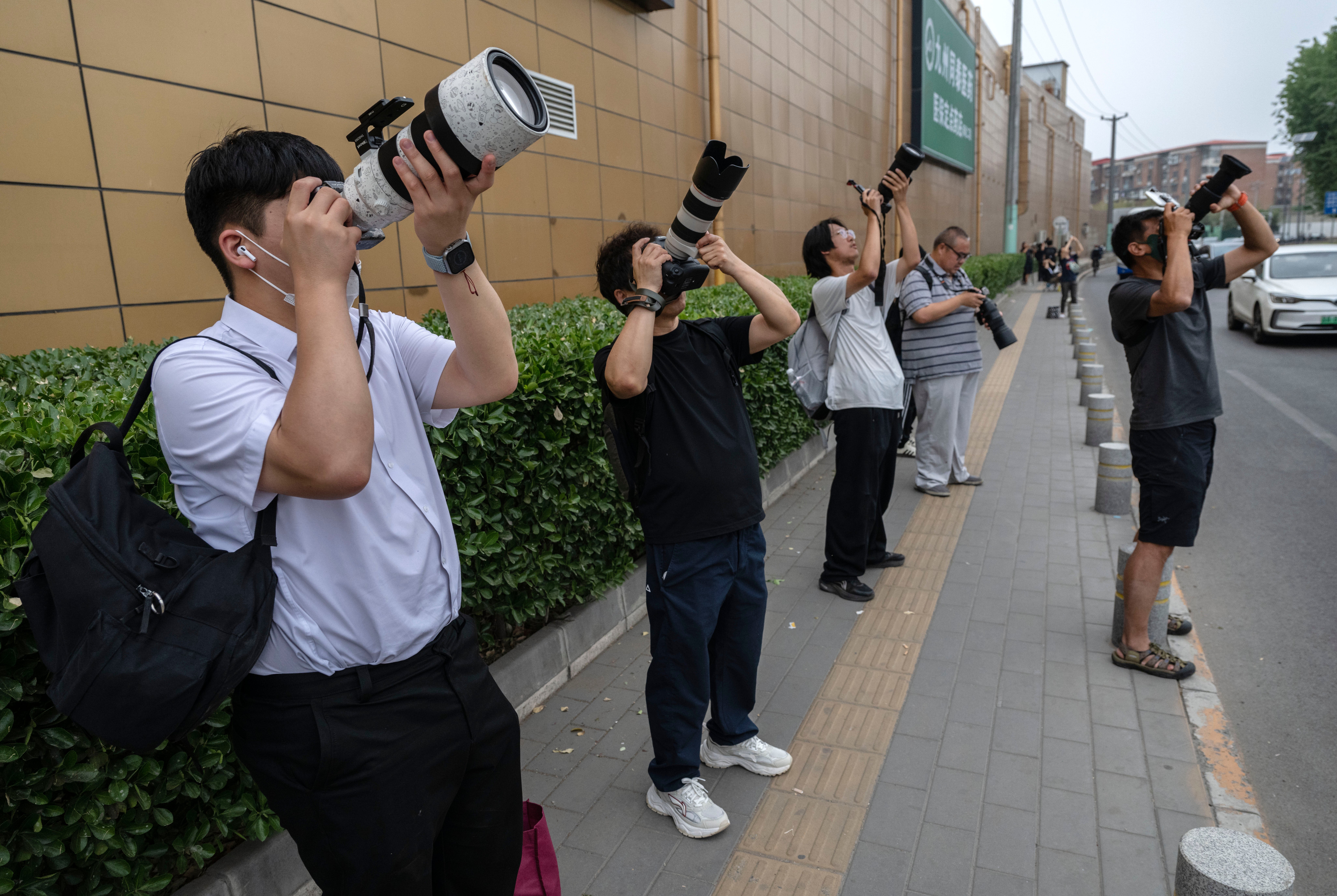Chinese plane spotters take photos of a plane taking off as they crowd to try to catch a glimpse of Air Force One taking off with U.S. President Donald Trump on board, outside Beijing Capital Airport (Getty)