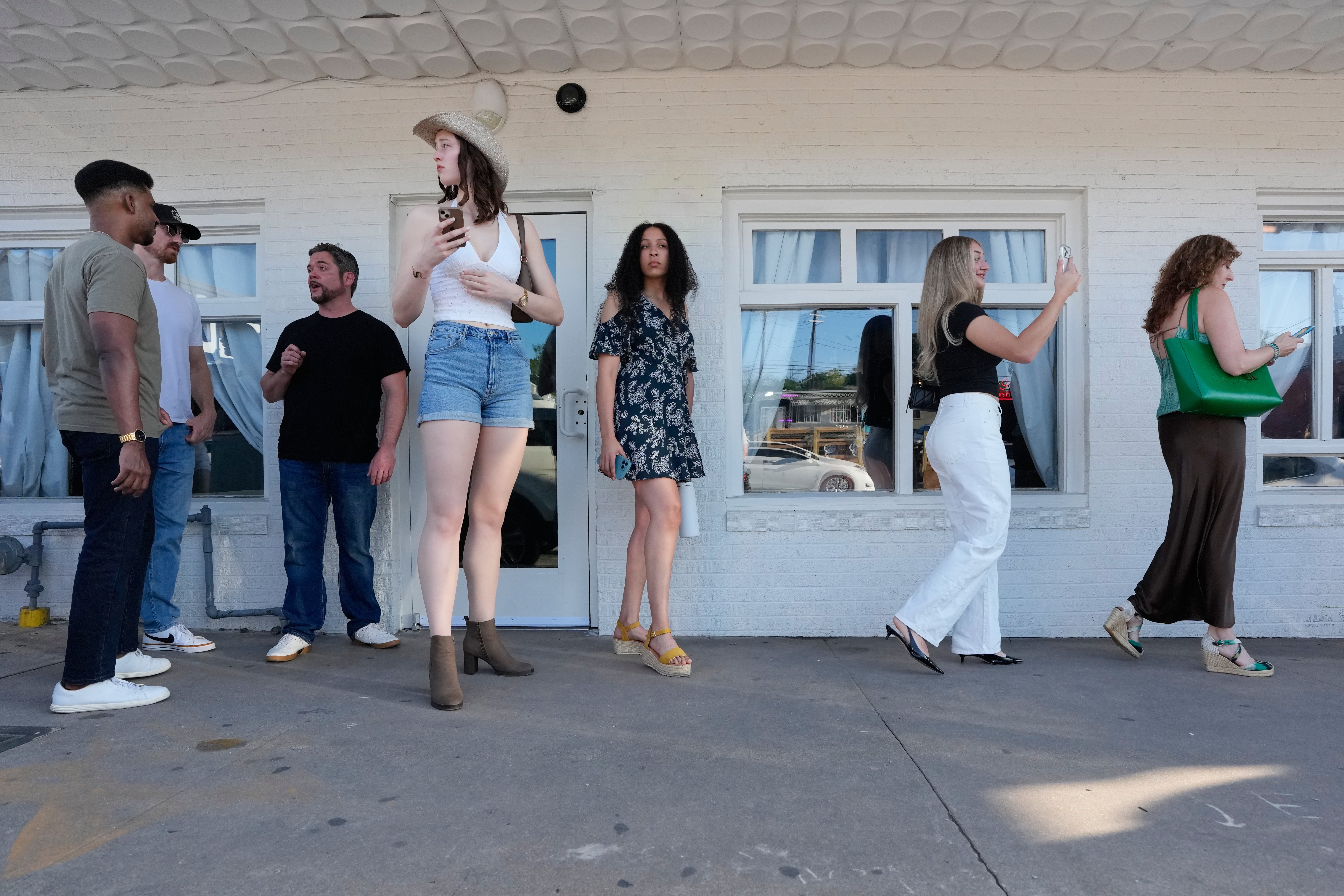 Celina Vilcinskas, center left, who is 6 feet, 8 inches tall, waits in line to enter a Tall Tour event