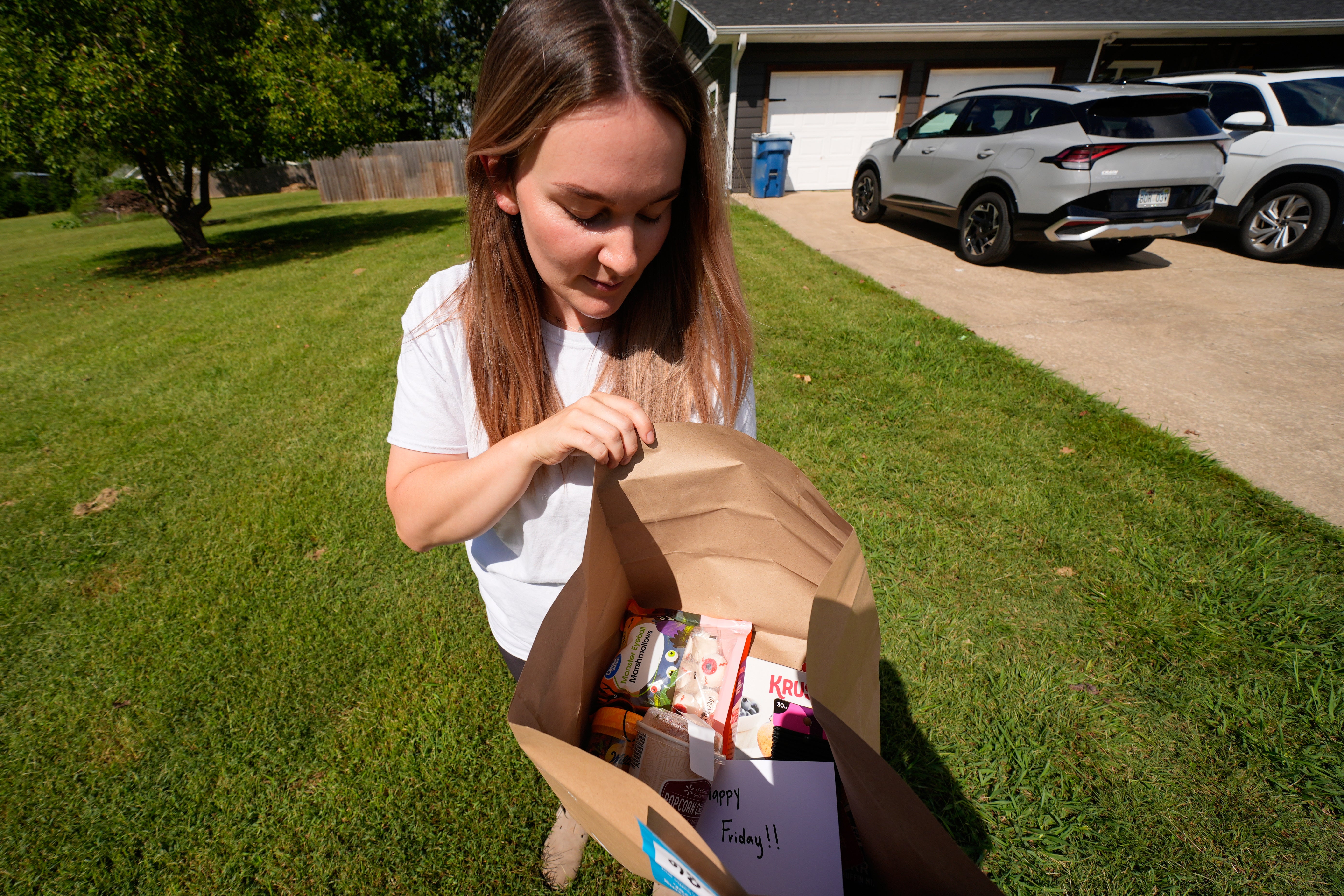 Emily Ingram checks her Walmart order after it was delivered by a drone operated by Zipline in Pea Ridge