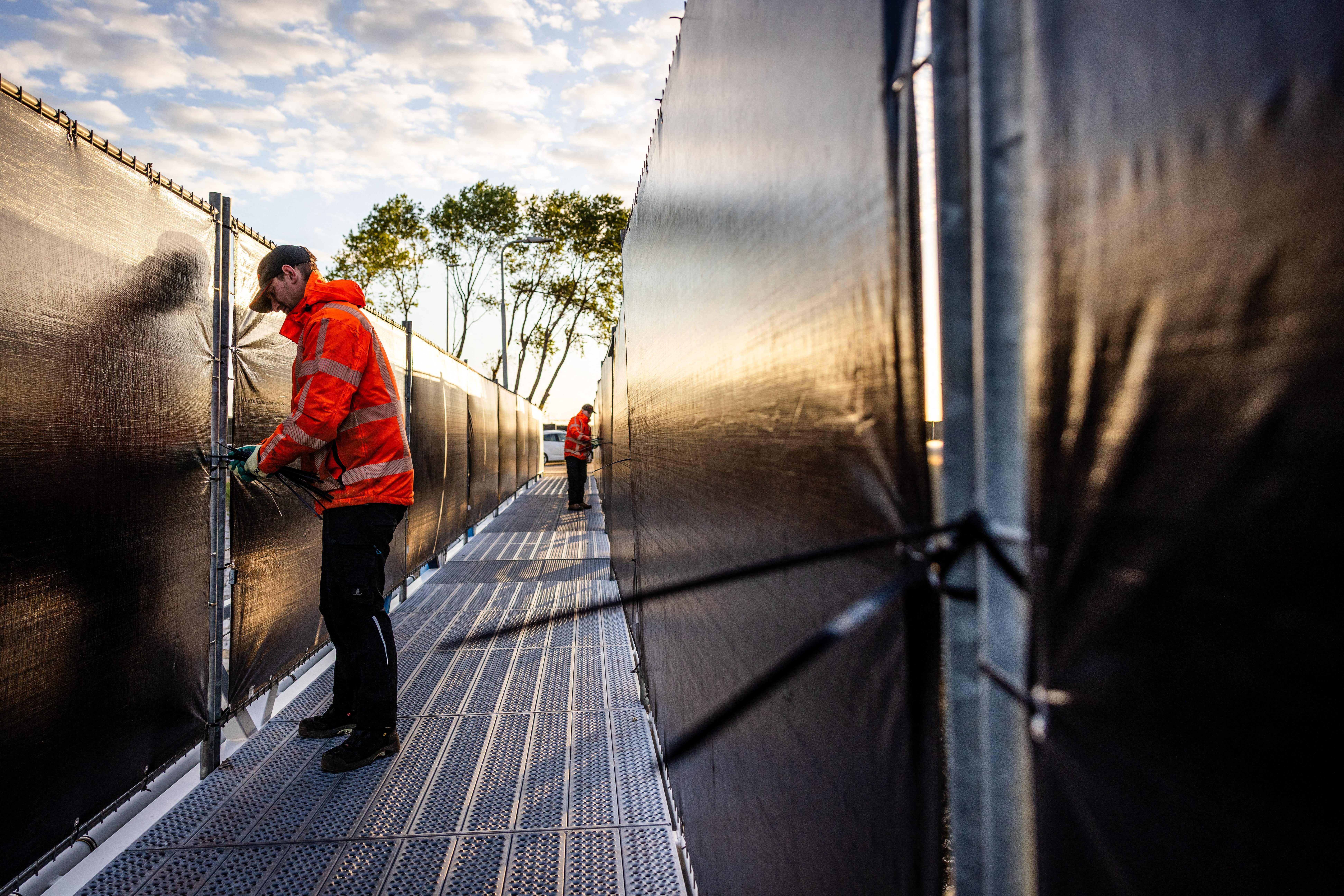 Employees prepare for the arrival of the Dutch Hantavirus-hit cruise ship MV Hondius at the port of Rotterdam on 16 May 2026