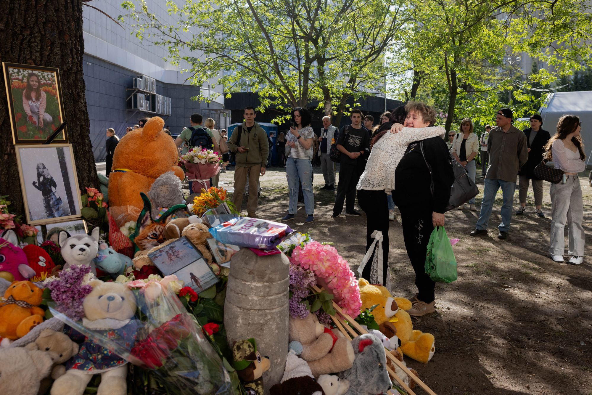 Local residents gather at a makeshift memorial near a partially destroyed residential building in Kyiv on May 15, 2026