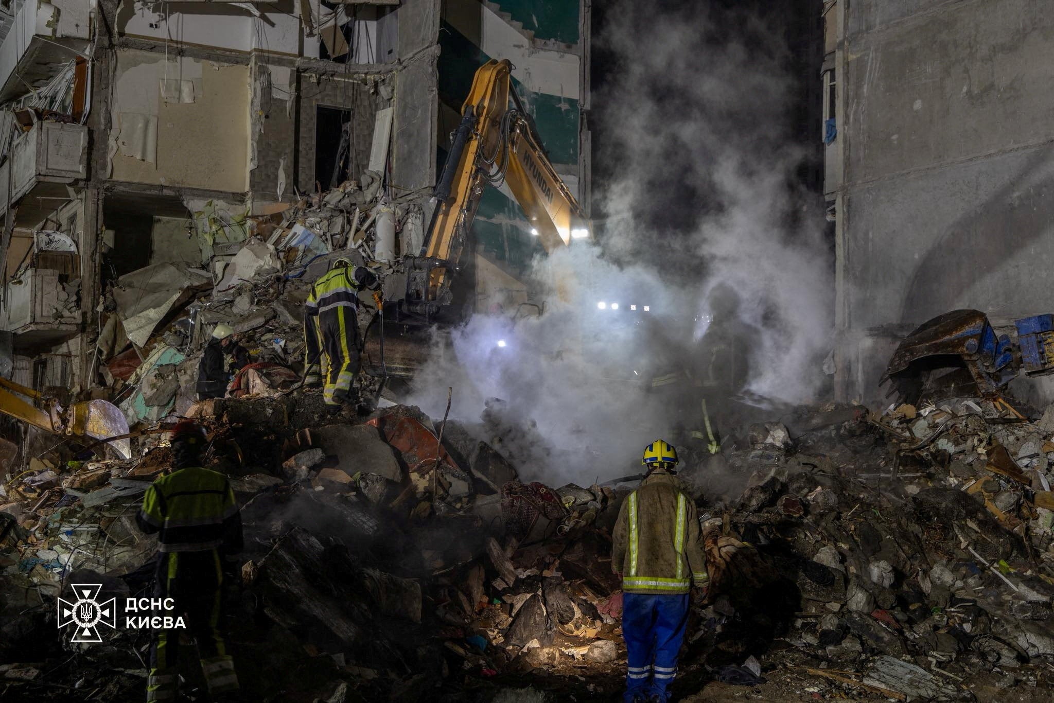 Emergency services working at the site of a damaged apartment building
