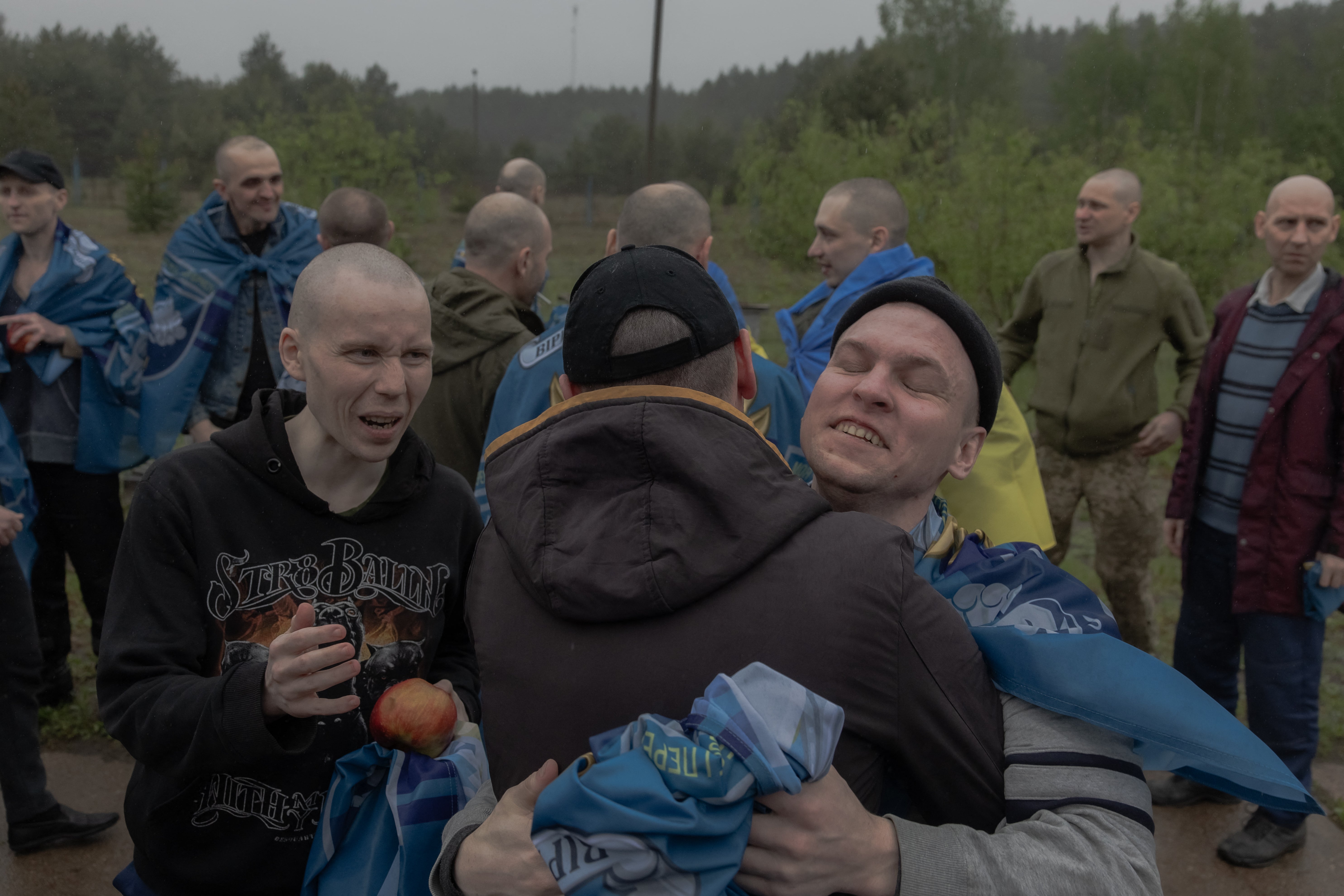Released Ukrainian prisoners of war (POWs) embrace each other following a prisoner exchange