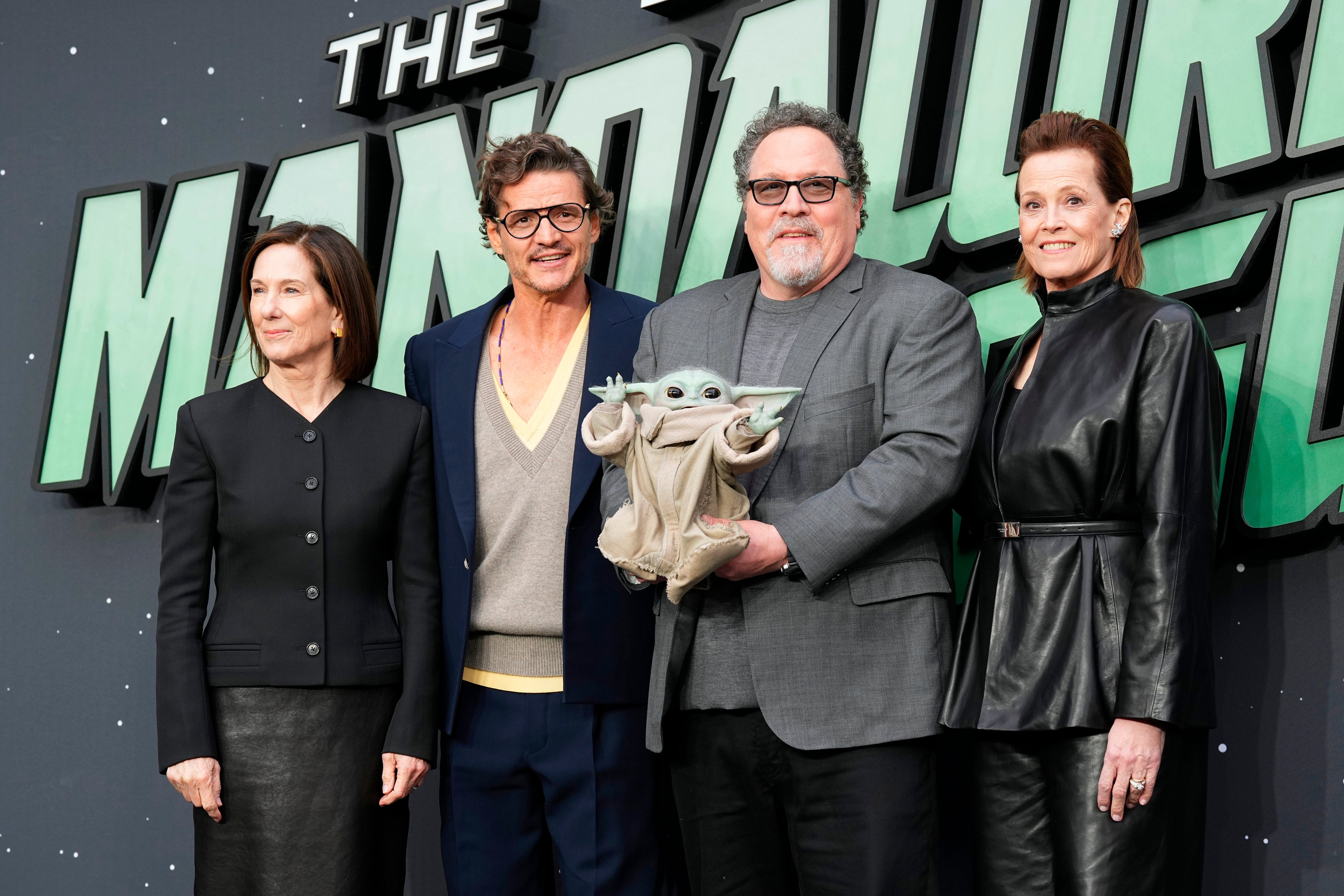 Kathleen Kennedy, Pedro Pascal, Director Jon Favreau, holding Grogu, and Sigourney Weaver attend a fan event for 'The Mandalorian and Grogu' in London