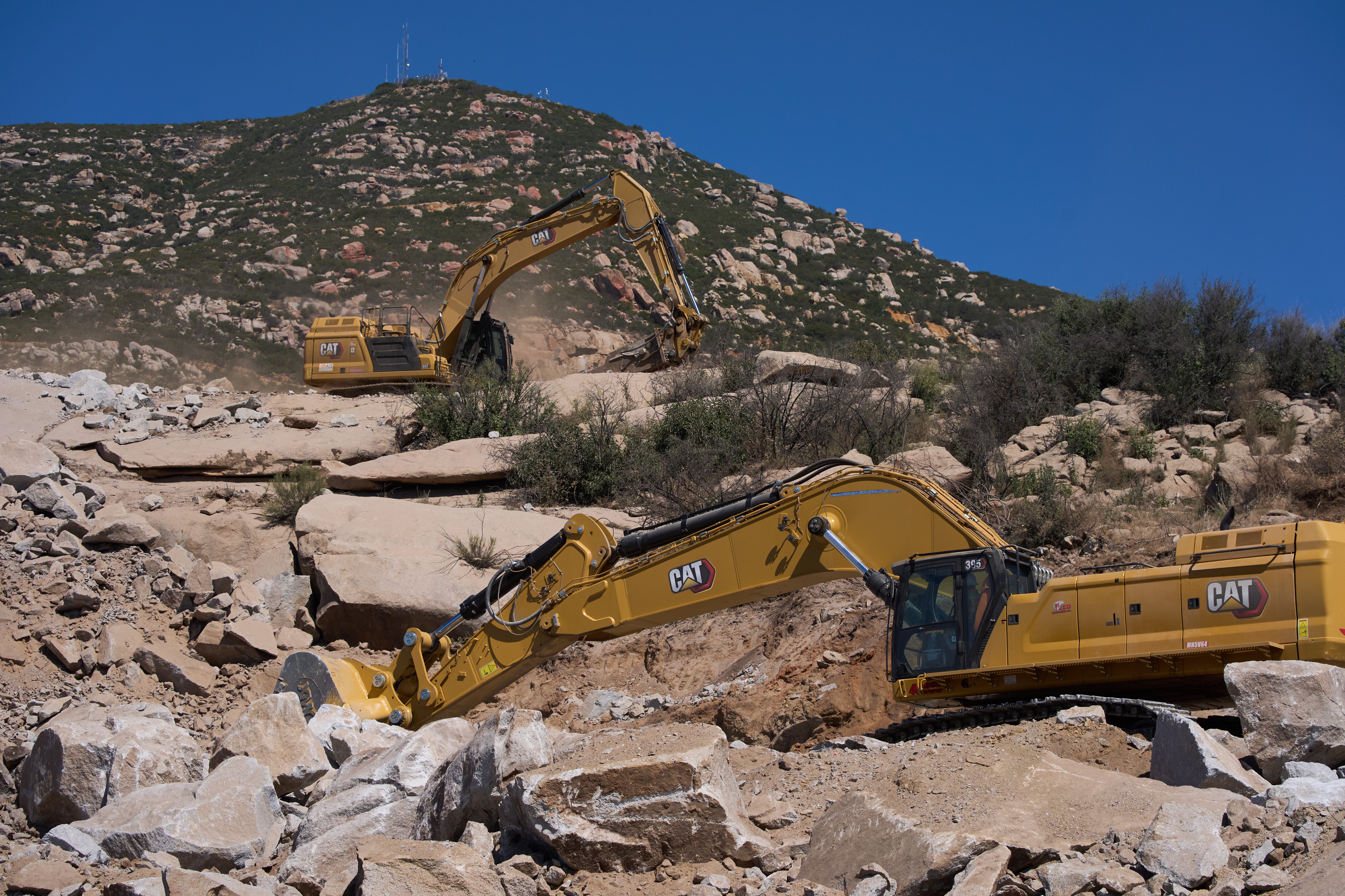 Construction crews work on a new border wall segment on Kuuchamaa Mountain