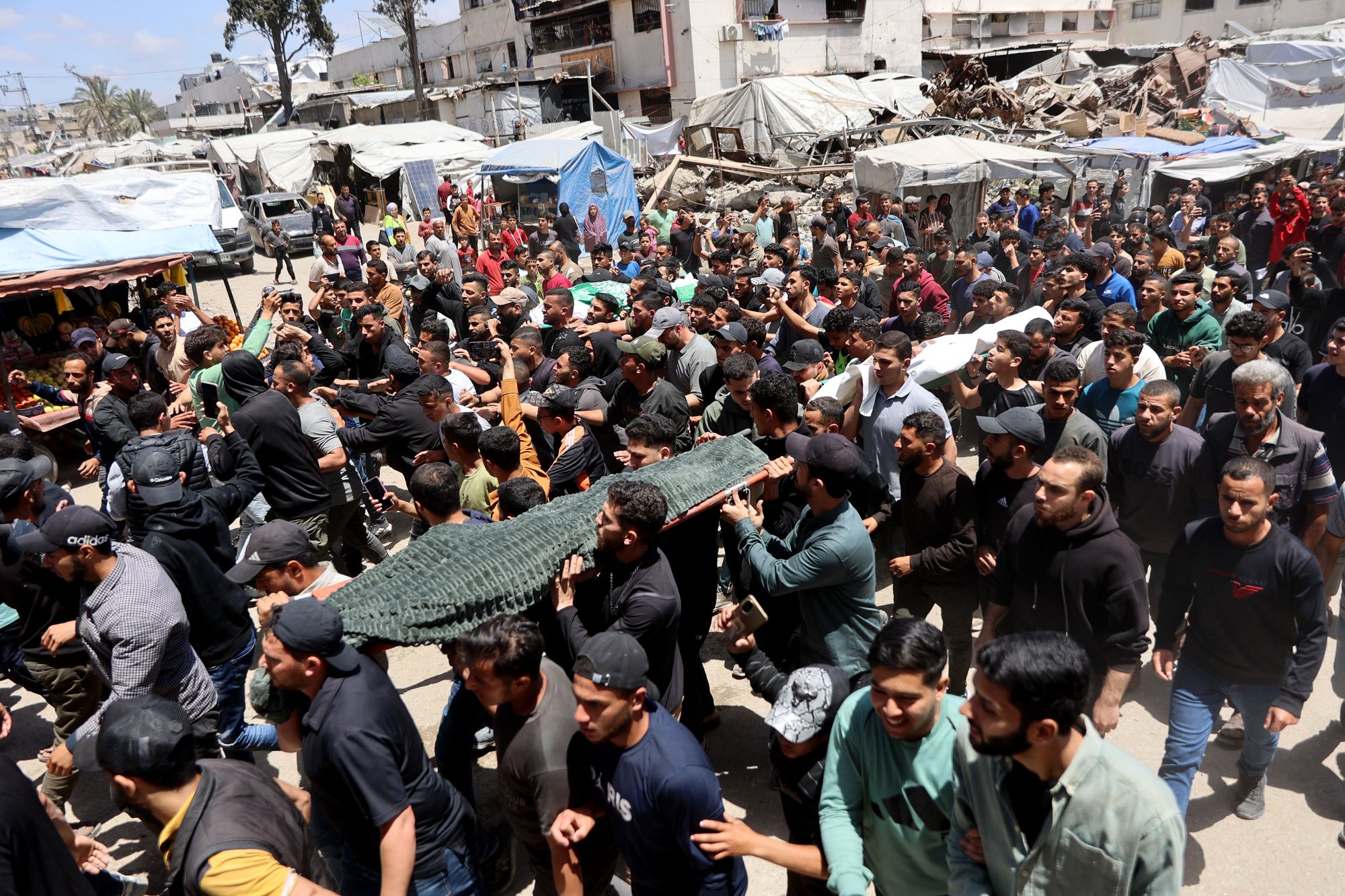 Palestinian mourners carry the bodies of Ezzedine Al-Haddad, the slain chief of the Qassam Brigade, who was targeted in an Israeli airstrike on Friday