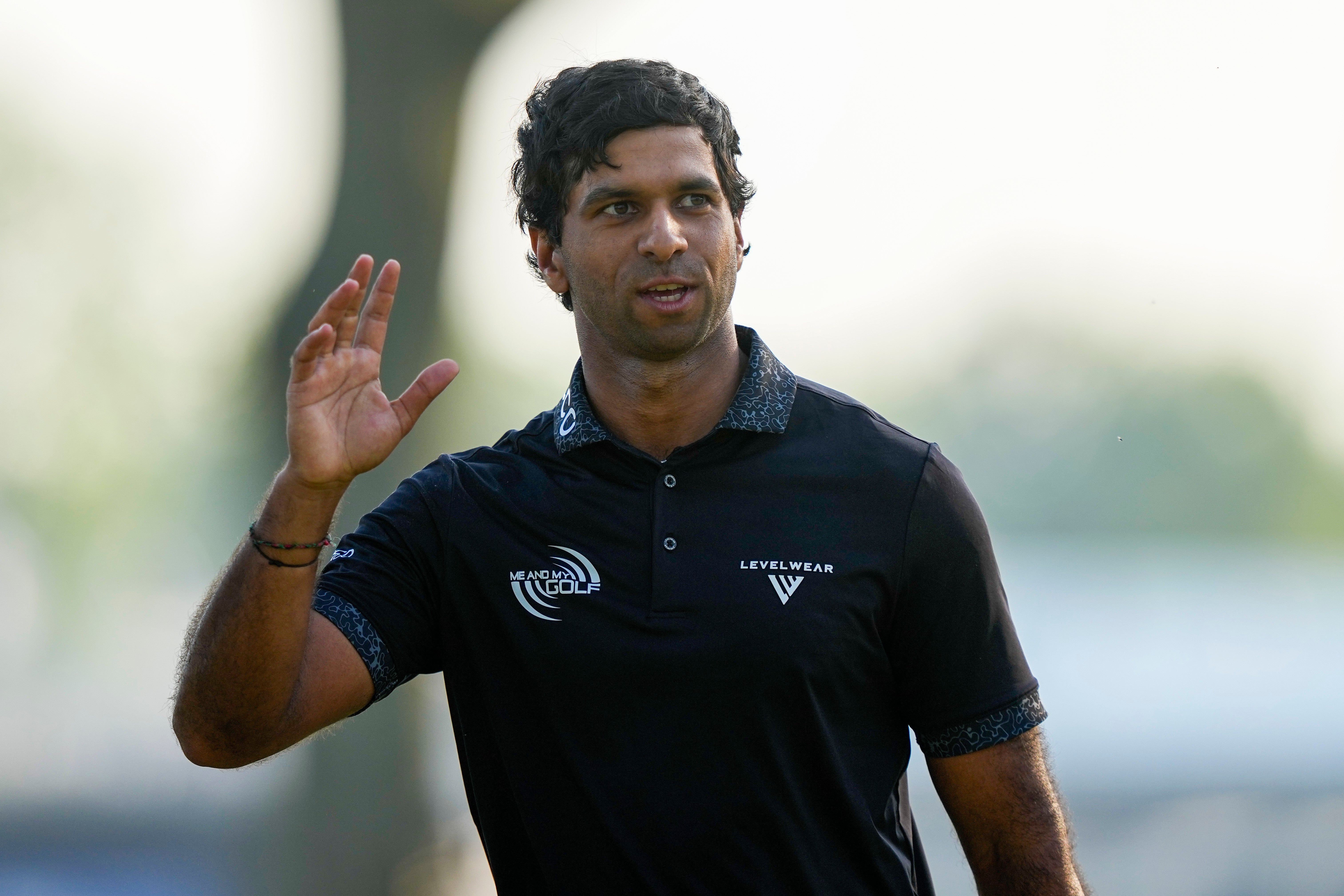Aaron Rai, of England, waves on the 18th green after his round