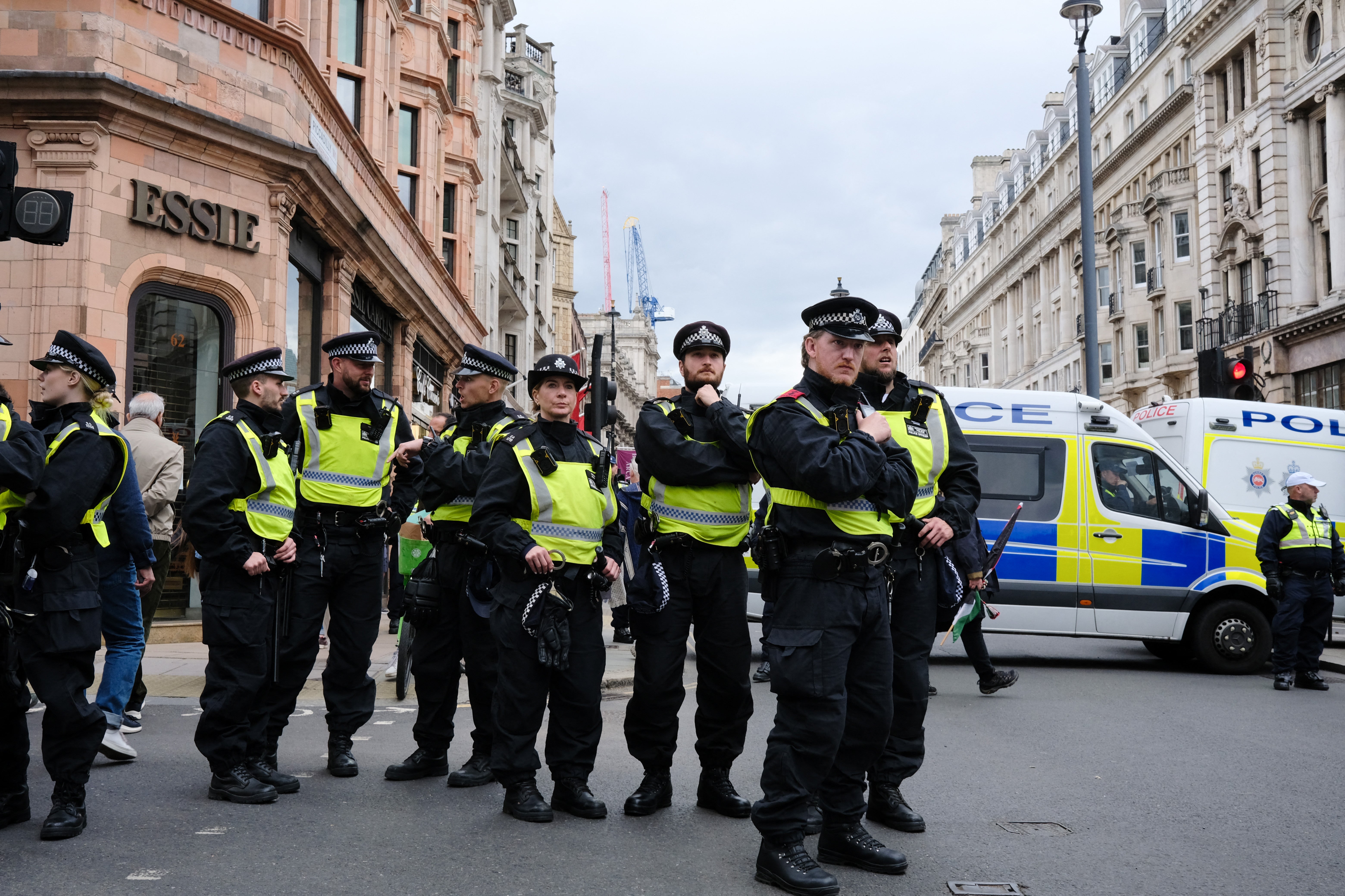 Police officers in response gear block a road to control the flow of a pro-Palestinian march in London