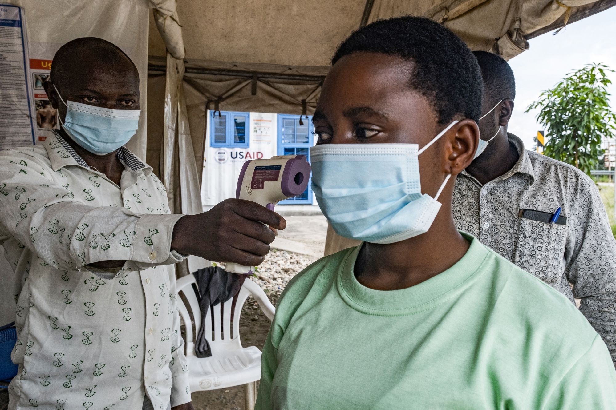 A border health officer at the Busunga crossing between Uganda and the Democratic Republic of Congo checks a traveler's temperature using a contactless infrared thermometer, as part of the ongoing response to the new ebola outbreak in East Africa