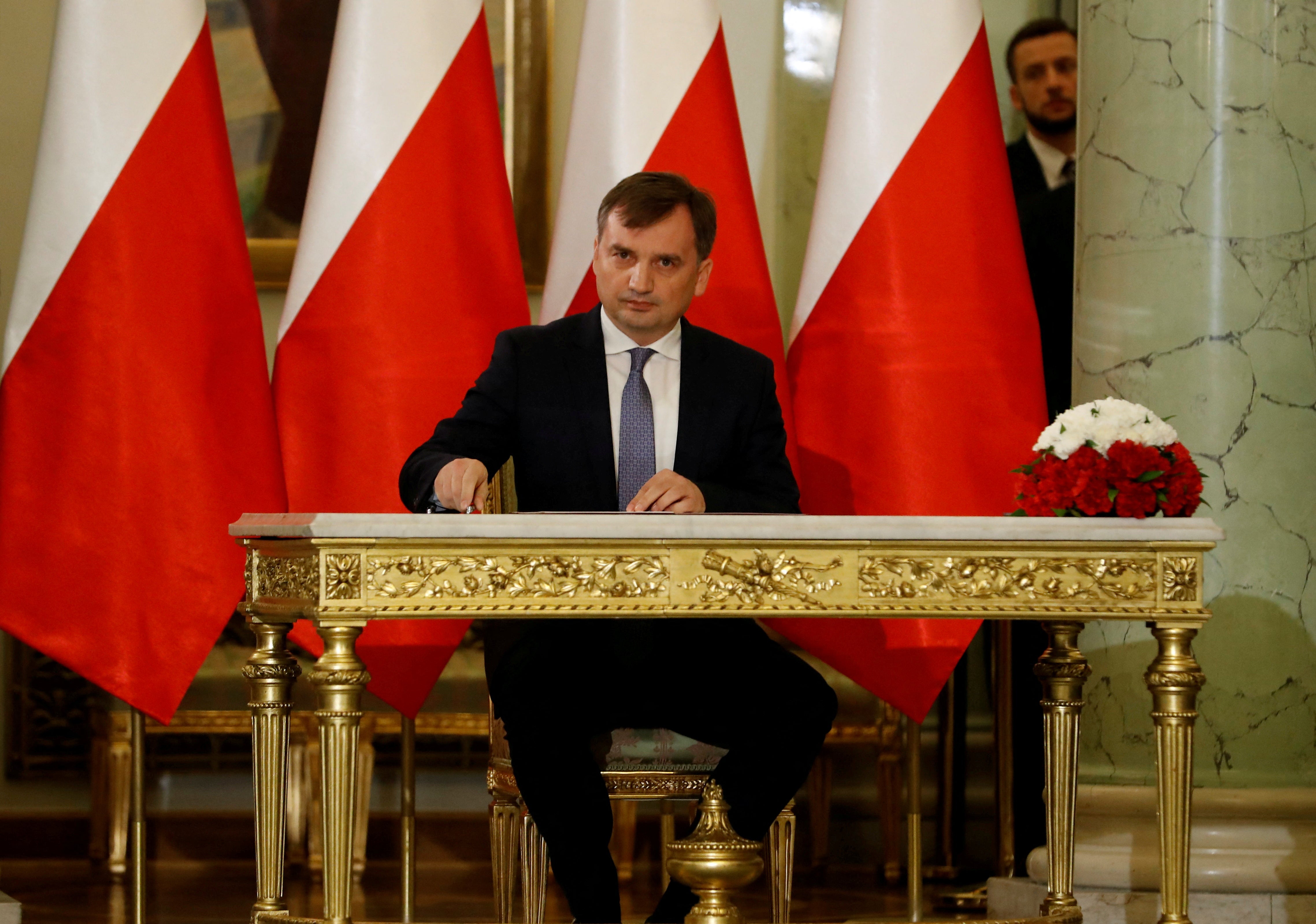 Zbigniew Ziobro signs documents after being designated as Minister of Justice at the Presidential Palace in Warsaw in 2019