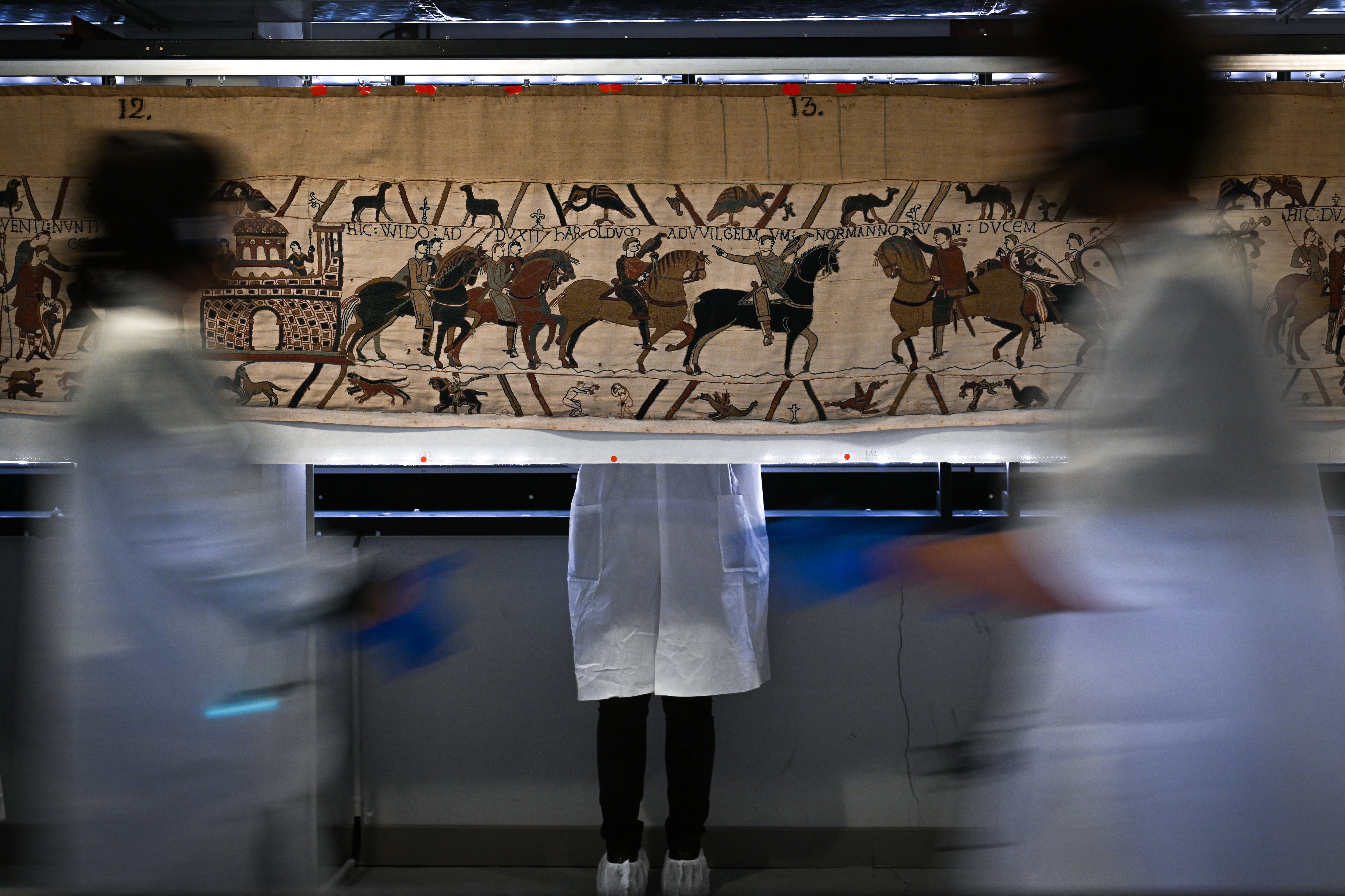 Workers and volunteers, rest before preparing to pack the Bayeux Tapestry in a crate for transfer to the British Museum