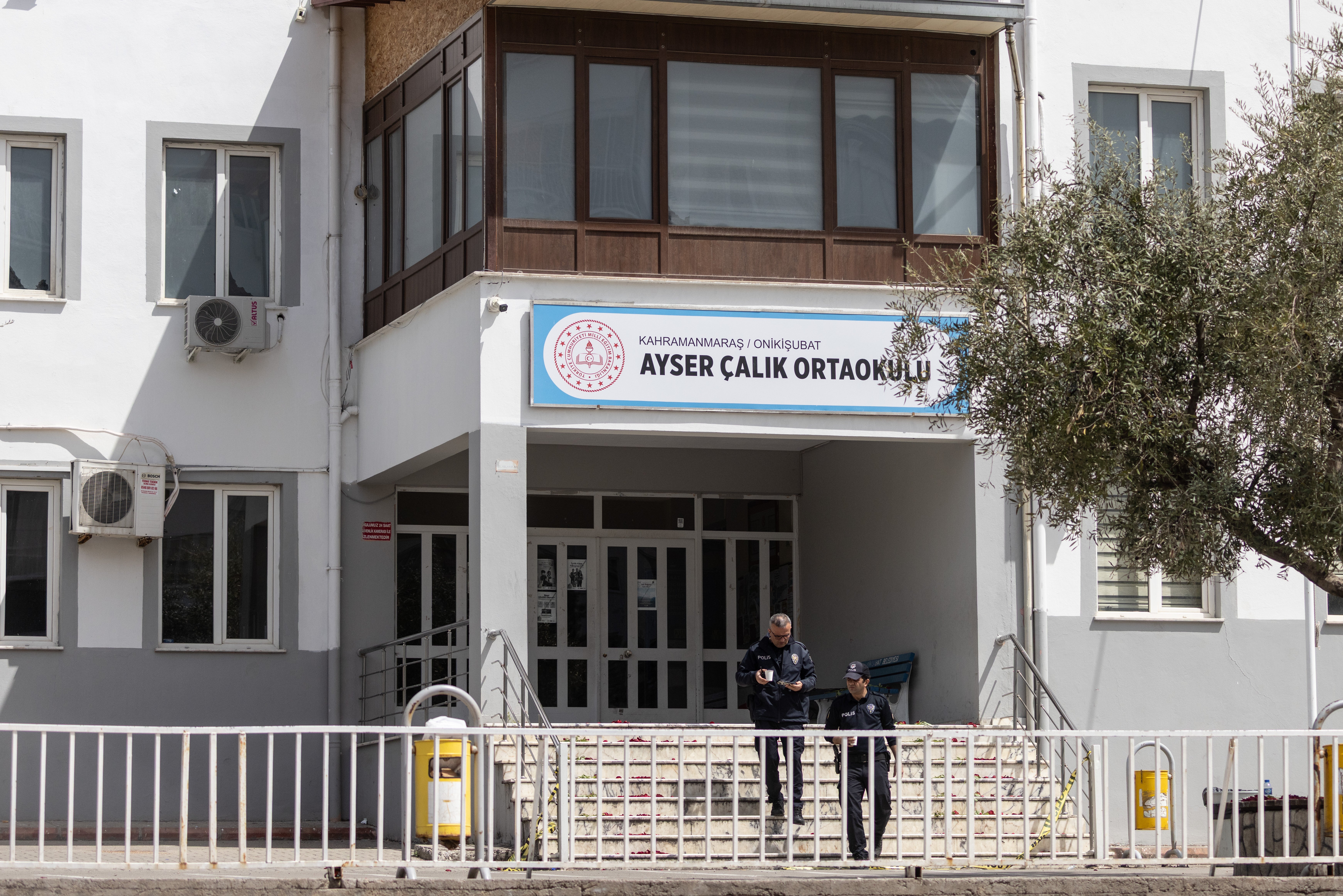 Police officers patrol in front of Ayser Calik middle school